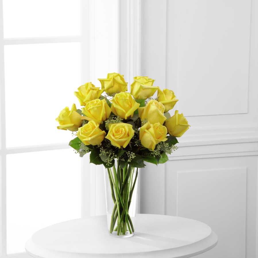 Yellow Rose Bouquet Yellow Rose Bouquet - Sunny yellow roses are a cheery and wonderful gift. Celebrate a birthday, anniversary, graduation or any occasion with this lively bouquet of roses with seeded eucalyptus in a clear glass vase. REGULAR bouquet is 12 stems with vase. DELUXE bouquet is 18 stems with vase. PREMIUM bouquet is 24 stems with vase.