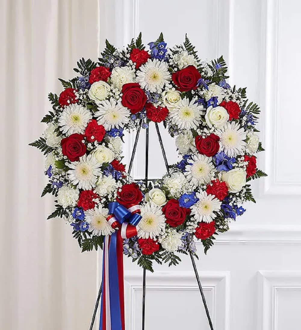 Serene Blessings Standing Wreath- Red, White &amp; Blue - The standing wreath arrangement is meticulously crafted to honor a special someone who has passed away. Filled with lush blooms in red, white, and blue, it’s a fitting final tribute for the funeral services. Appropriate for the funeral home  DETAILS Standing wreath arrangement with red roses, carnations, white roses, cremones, carnations, blue delphinium, baby’s breath and greenery.  EASEL INCLUDED Orientation: One-Sided *If you would like to add a ribbon with a sentiment for an additional $10 Item #NF-1114  FLORIST-TO-DOOR Same day flower delivery on most orders placed online by 12 pm or 10 am on weekends PST.  BLOOM DETAILS Roses Cremons Delphinium Carnations Filler Greenery  The Standard Arrangement is approx. 31” H x 31” W (31&quot; in Diameter) without an easel. The Deluxe Arrangement is approx. 33” H x 33” W (33&quot; in Diameter) without an easel.  The Premium Arrangement is approx. 35” H x 35” W (35&quot; in Diameter) without an easel.  INSTRUCTIONS: 1.) Please have the business name of the funeral home, address &amp; phone number. 2.) Please have the first name &amp; last name of the deceased. 3.) Please have the start time of the services.  How to place an order?  1. You can place an order directly on this secure website. OR 2. You can call in your order by dialing: (323) 262 - 9238 OR 3. You can visit our store (appointment recommended 323.262.9238)  NINFA'S FLOWERS 2405 WHITTIER BLVD. LOS ANGELES, CA. 90023
