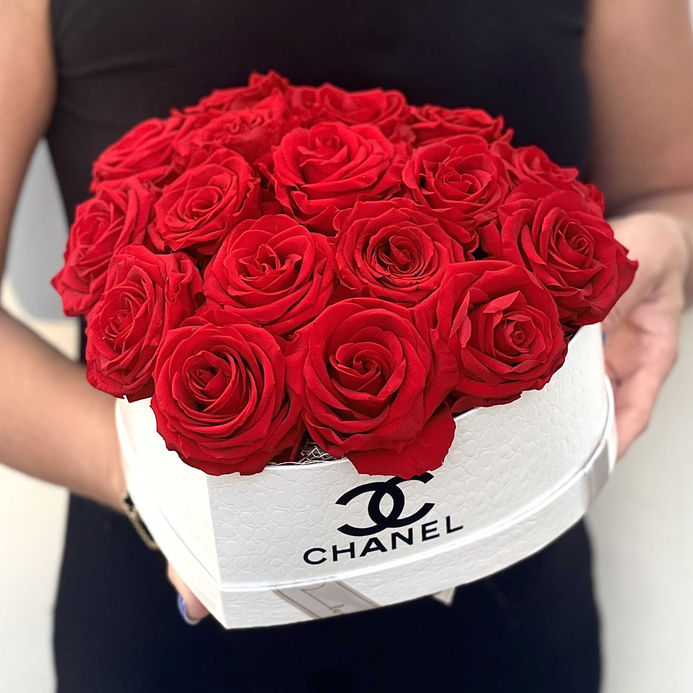 Red Chanel: Eternal Box Red Chanel: Eternal Box - Embrace the essence of everlasting love with our Eternity Love Chanel Heart Floral Box. This exquisite creation features a heart-shaped white floral box adorned with the iconic Chanel logo and showcases a stunning arrangement of 18 meticulously preserved red roses, crafted to stand the test of time. Radiating timeless elegance and romance, each rose serves as a symbol of enduring love and passion. Whether presented as a grand gesture of affection or as a statement piece in your home, the Eternity Love Chanel Heart Floral Box is a luxurious expression of love that will captivate hearts for years to come.