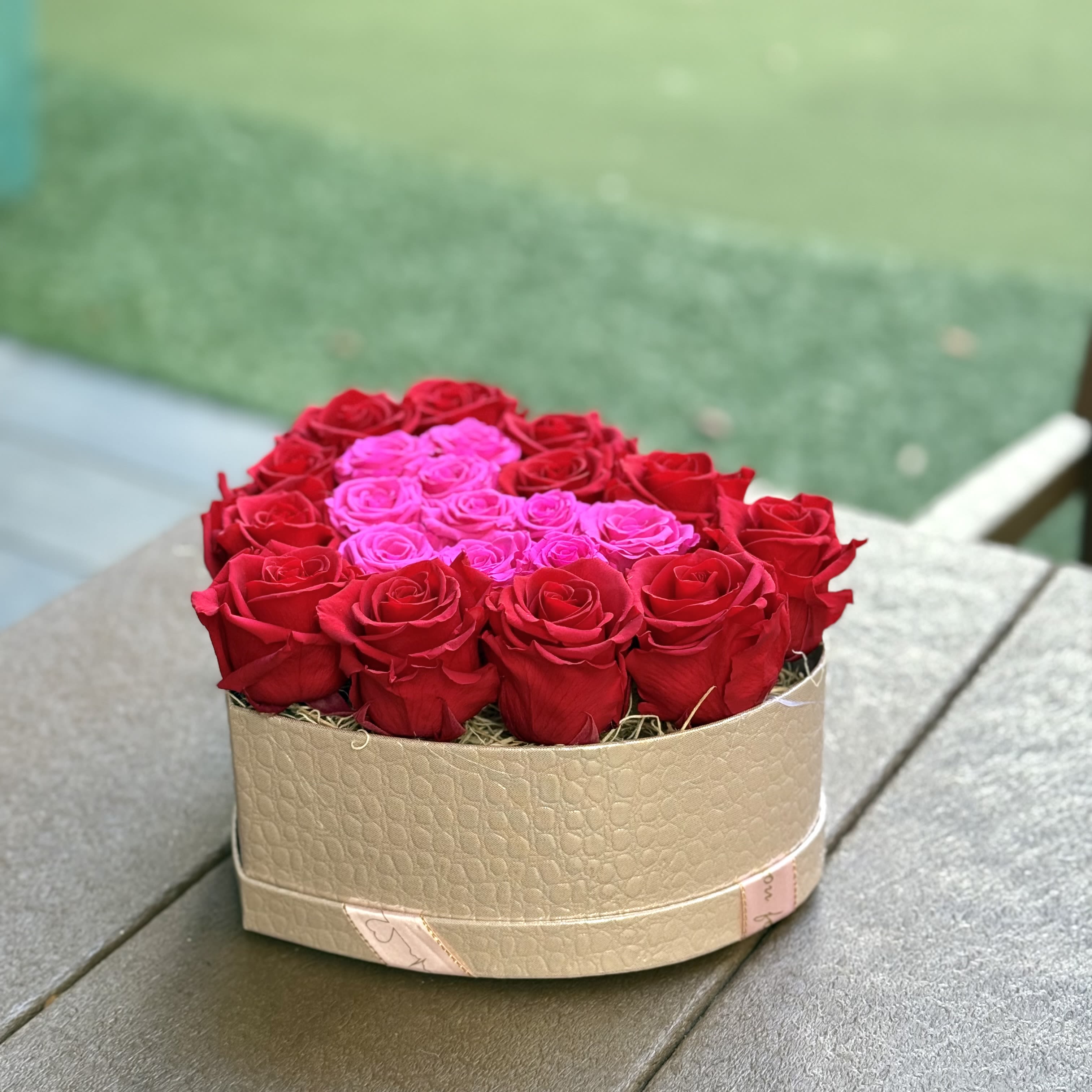 Tropical Love: Forever Rose Heart Medium - This heart-shaped preserved rose box features a bold ombré effect with deep red roses on the outer edges and vibrant mini hot pink roses inside. Designed to last, this modern arrangement brings a fresh, elegant touch to any space, making it the perfect gift for Valentine’s Day or any special occasion. Celebrate love with timeless beauty!