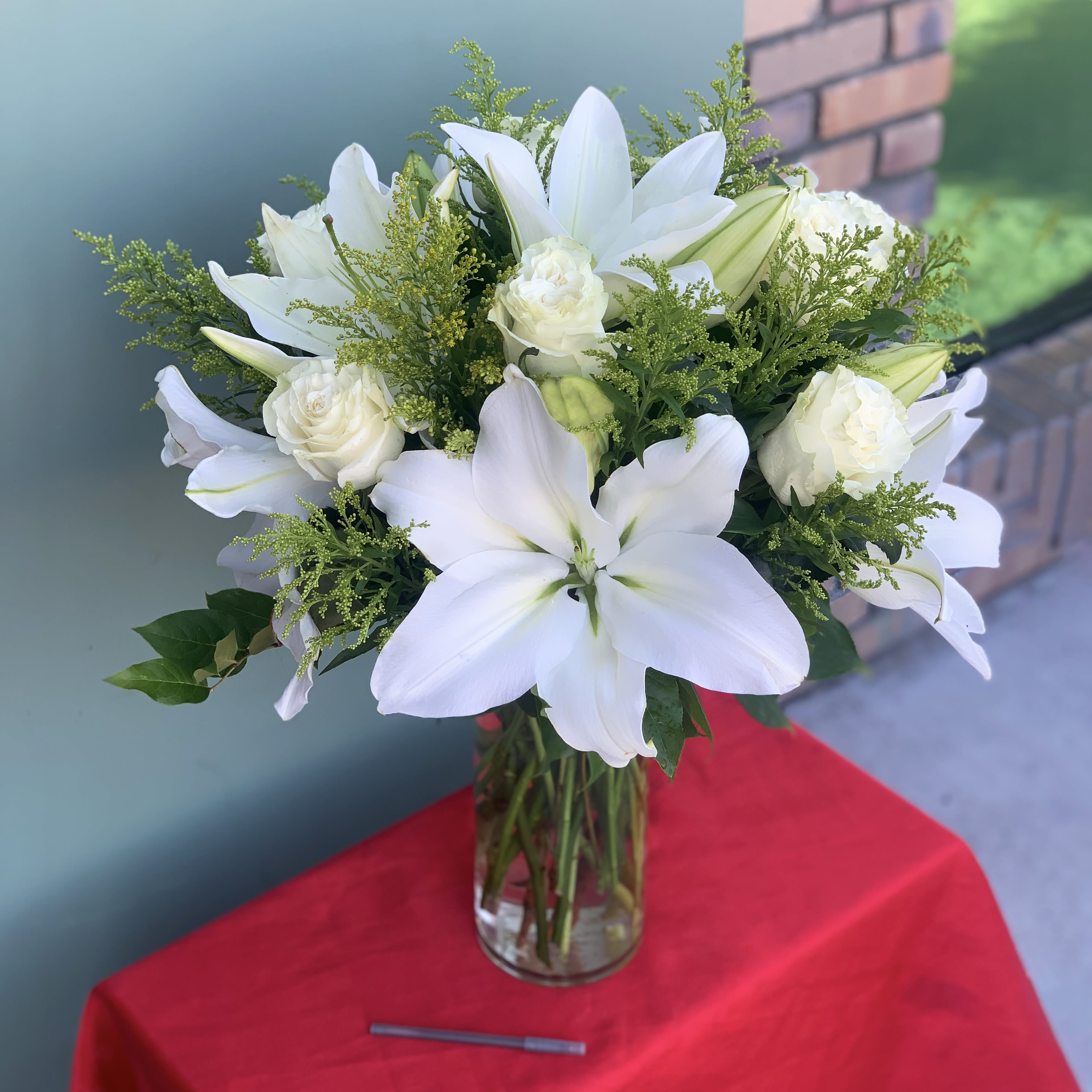 White Love - Give the gift of elegance to the special person in your life. A delightful blend of white roses and lilies with greens and filler are beautifully designed in a tall glass vase.  Approximate Dimensions: 24&quot;H X 17&quot;W