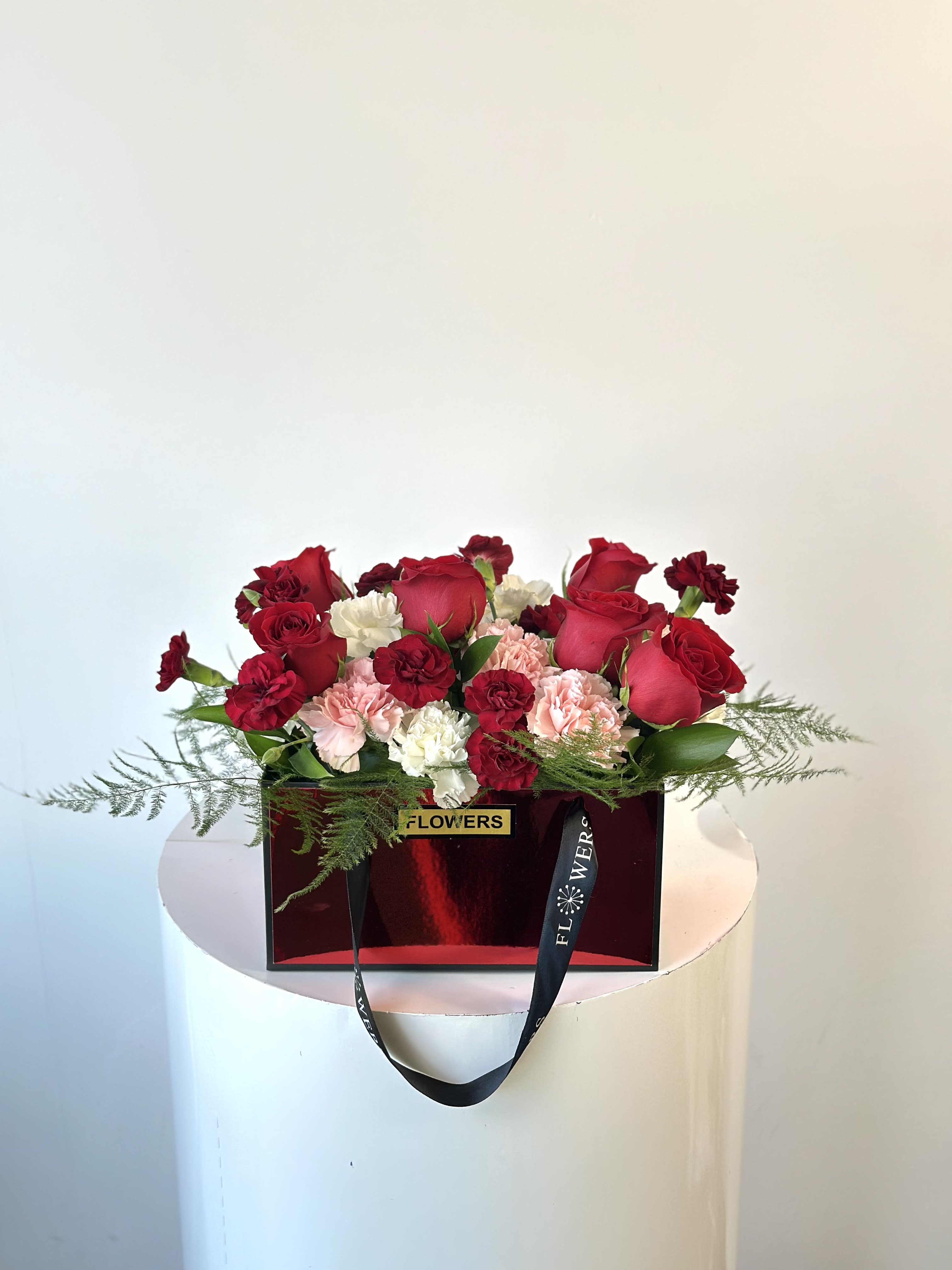 Forever Yours - Celebrate timeless love with Forever Yours, a stunning arrangement of vibrant blooms in shades of red, pink, and white.  Presented in an elegant rectangular red floral bag.  This design blends romance and charm for an unforgettable gift. Perfect for Valentine’s Day!  Forever Yours is a heartfelt expression of love that will leave a lasting impression.