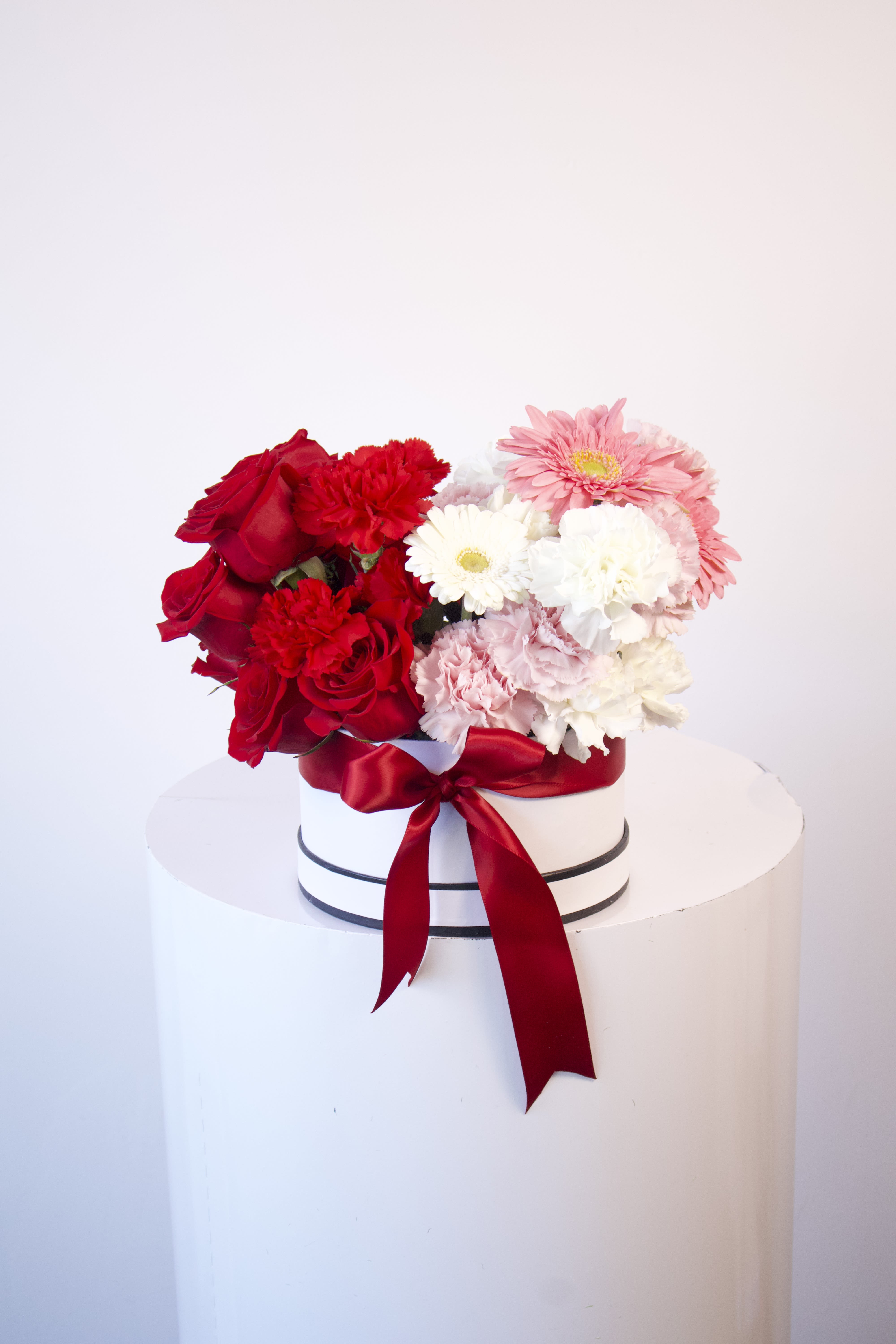 Love Box - Valentine’s Collection  Red and pinks are always in style and this piece is simply exquisite! Show your love with special half red half pink and white design box arrangement.  Sure to put a smile on the person that means the most!  Arrangement includes: - Floral box - Fresh flowers - Flower care instructions card - Greeting card