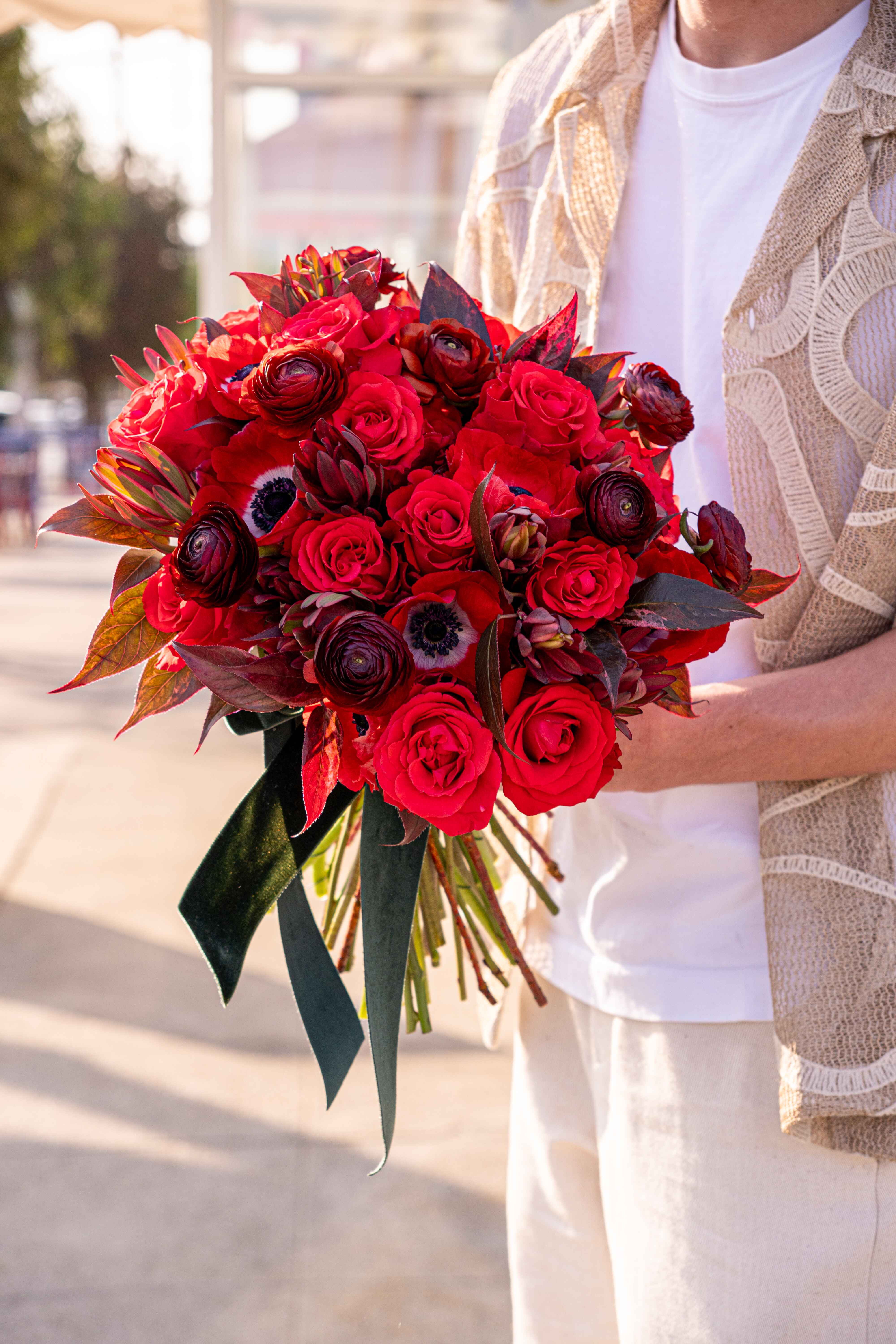 №209 Fiery Passion - &quot;Fiery Passion&quot; perfectly reflects its intense and romantic feel. The bouquet features a striking combination of deep red roses and ranunculus, creating a lush, velvety texture that embodies timeless elegance and deep emotion. The bold red hues are balanced by layered textures and dark, rich foliage, which add depth and dimension, making the arrangement even more captivating. &quot;Fiery Passion&quot; stands out as a powerful expression of love and desire, allowing you to convey your feelings in a way that is both bold and unforgettable.