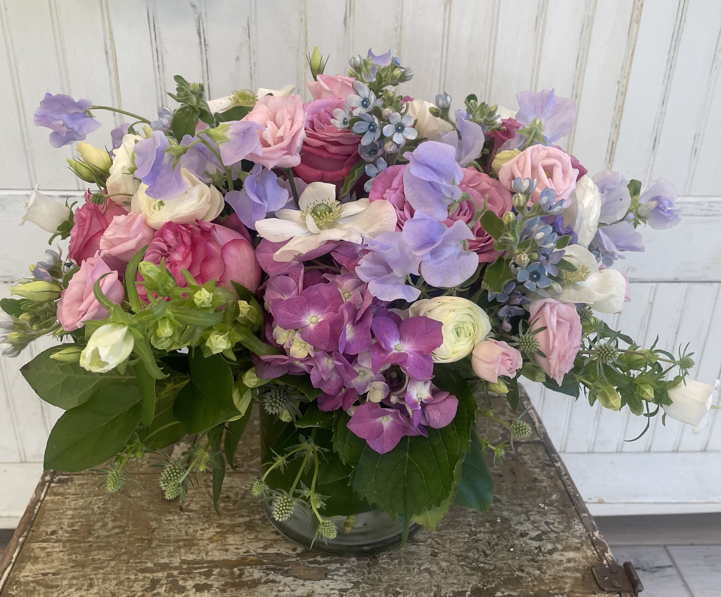 Just Gorgeous - Roses, hydrangea, ranunculus, campanula, spray roses, tweedia, lisianthus, thistle and sweet pea in a vase.