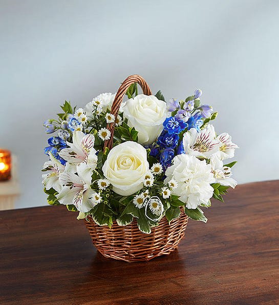 Peace, Prayers &amp; Blessings™ Blue &amp; White - Offer peace and comforting prayers during times of loss with elegant blue and white blooms. Artistically designed inside a keepsake willow basket, our arrangement of heavenly blue delphinium and white roses is a touching way to convey your sincerest blessings.