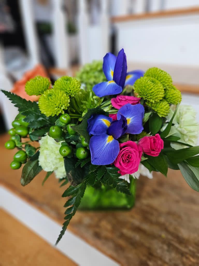 Iris Cube Arrangement - Iris, hot pink spray roses, green carnations, green button poms and green hypericum berries arranged in a green glass cube
