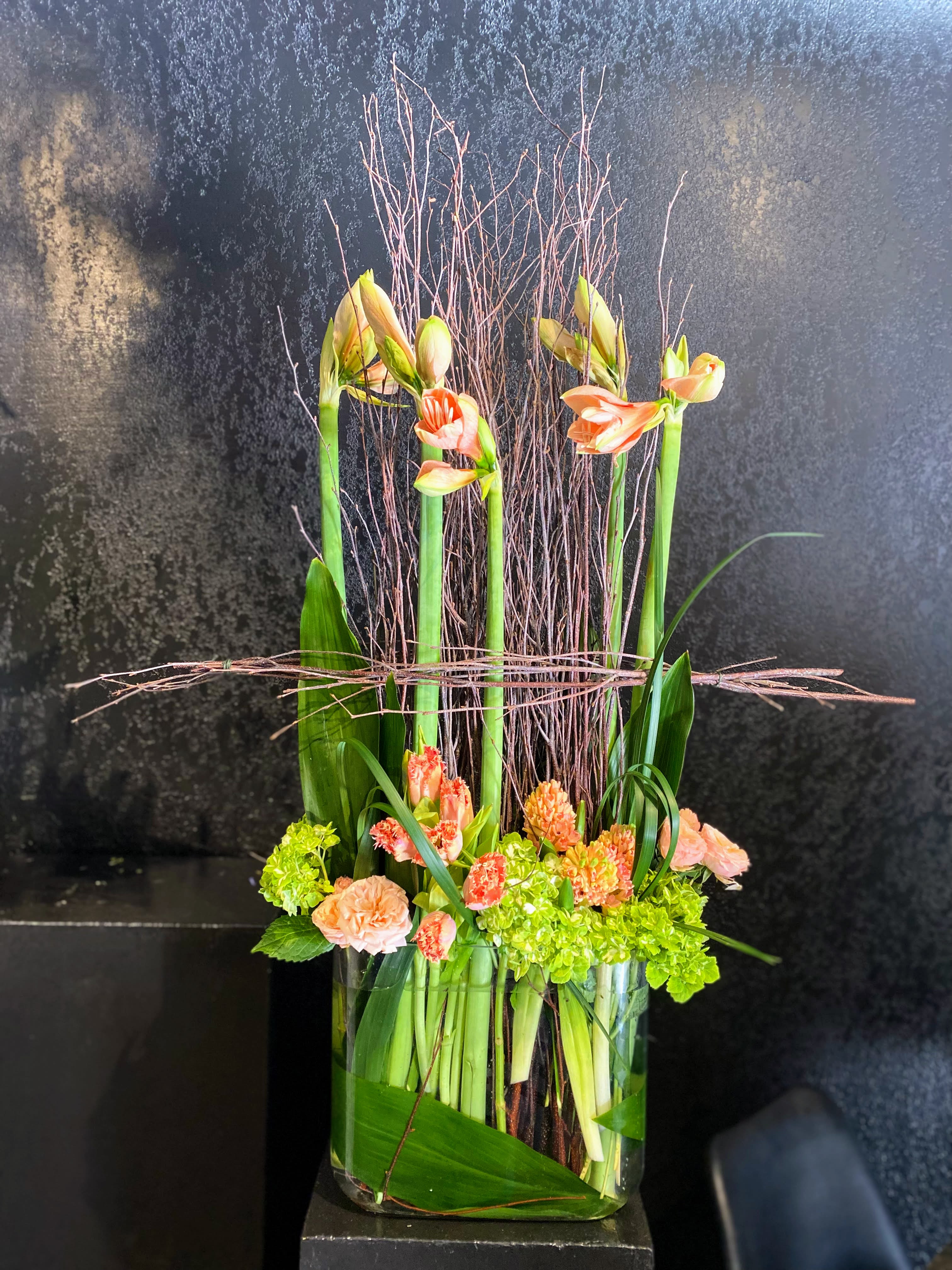 Laura - A gift made as a Thank You for a favorite client.  We thought it was too good not to let others choose it as their thank-you gift.   This design includes monochromatic flowers, unique structured branches, and a large glass container measuring approximately 4&quot; in depth, 12&quot; wide, and 8&quot; in height.  Due to the unique materials used in this design, not all materials will be available year around meaning we cannot guarantee a strict recreation; however, the overall temperament and feeling will carry on to your purchase as the designer's discretion. Should you wish for specific colors or flowers, feel free to reach out to us in advance. 