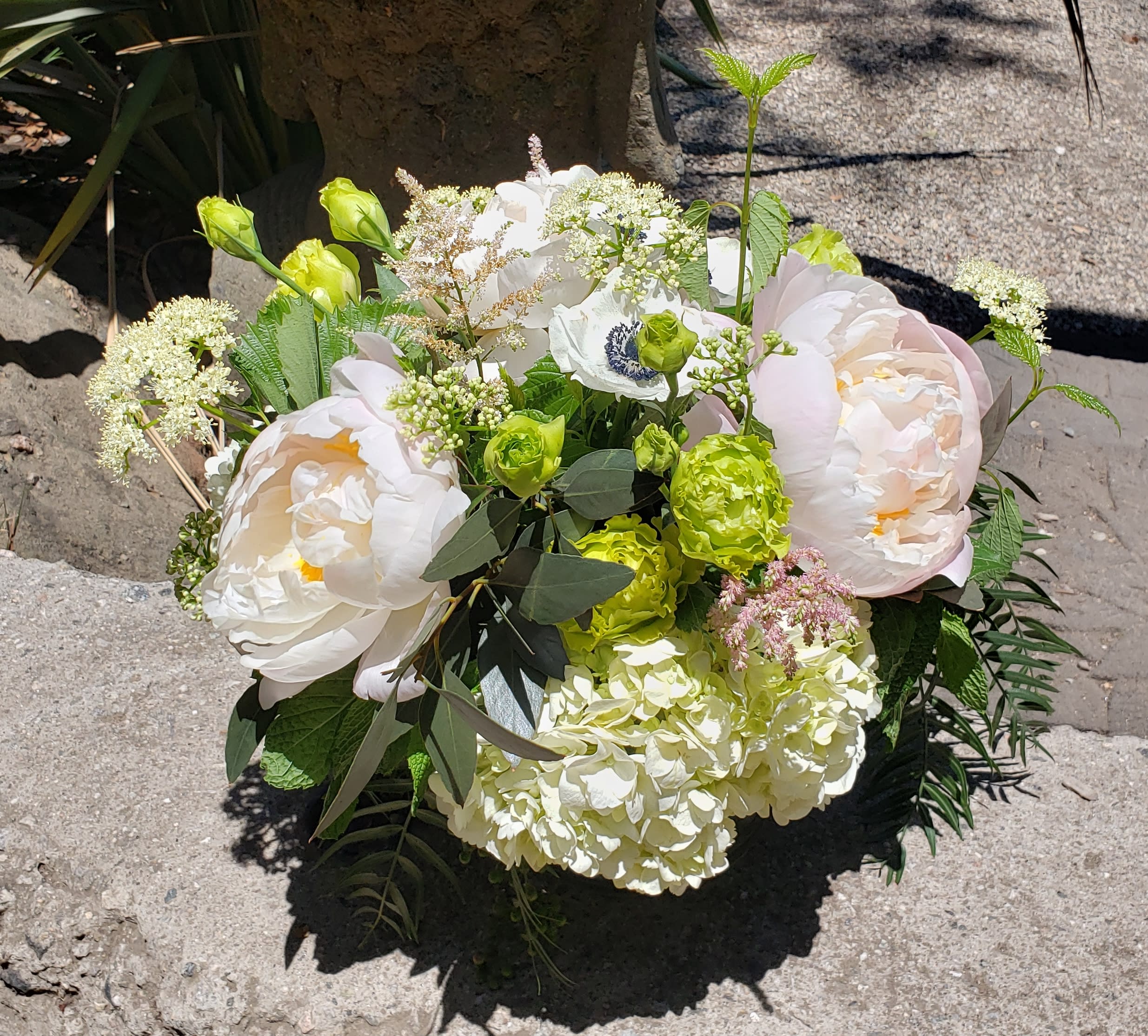 Spring Elegance - A seasonal collection of mixed blush and white tones with bright green accents and texture in a clear glass cylinder vase.  Flowers might include peonies, lisianthus, ranunculus, anemones, astilbe, eucalyptus, pepper berry, and other premium seasonal blooms and textures. 