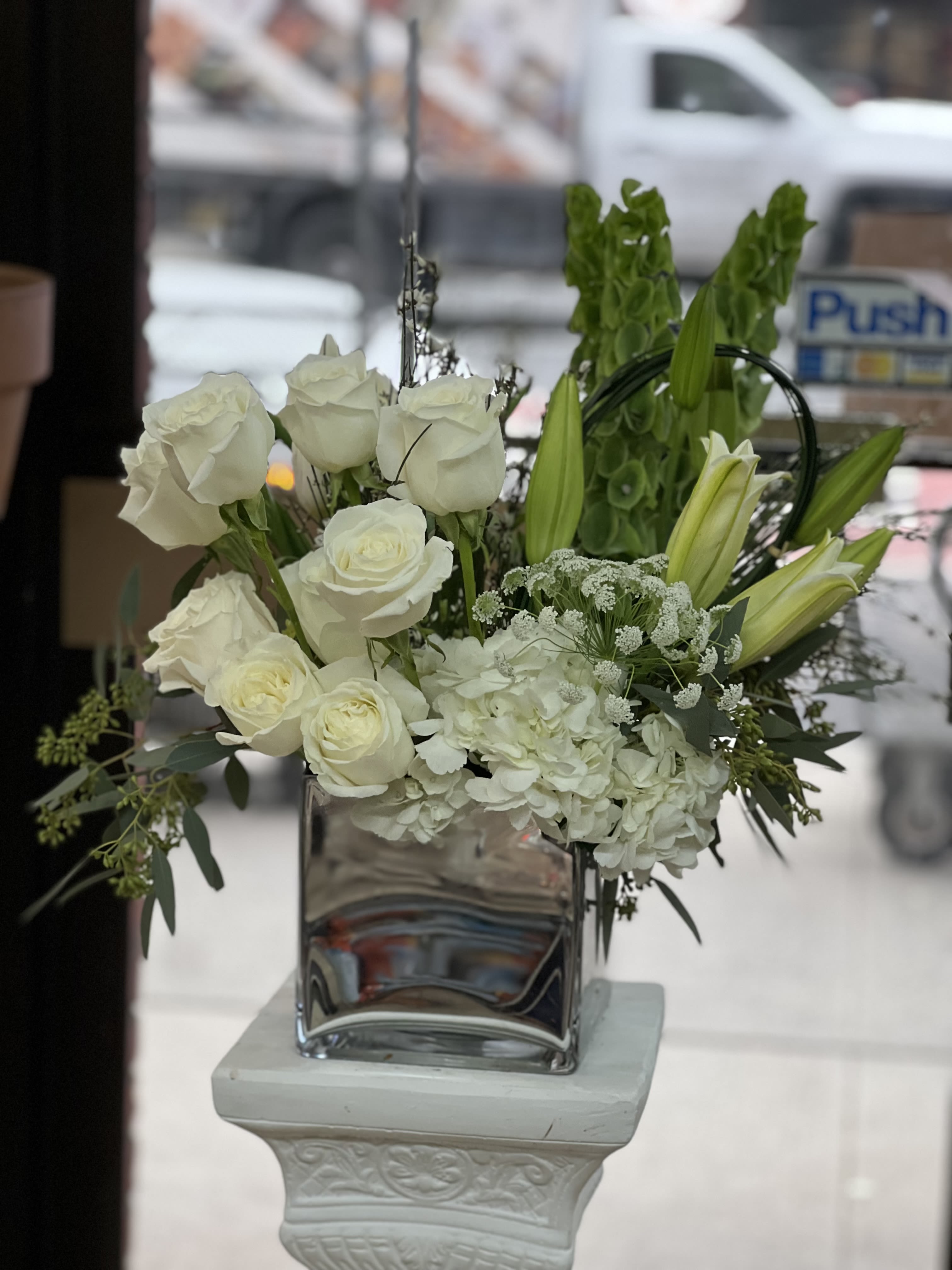 Vows  - This lovely arrangement in a vase of mostly whites and hints of green is the perfect centerpiece for a gift or for an event !