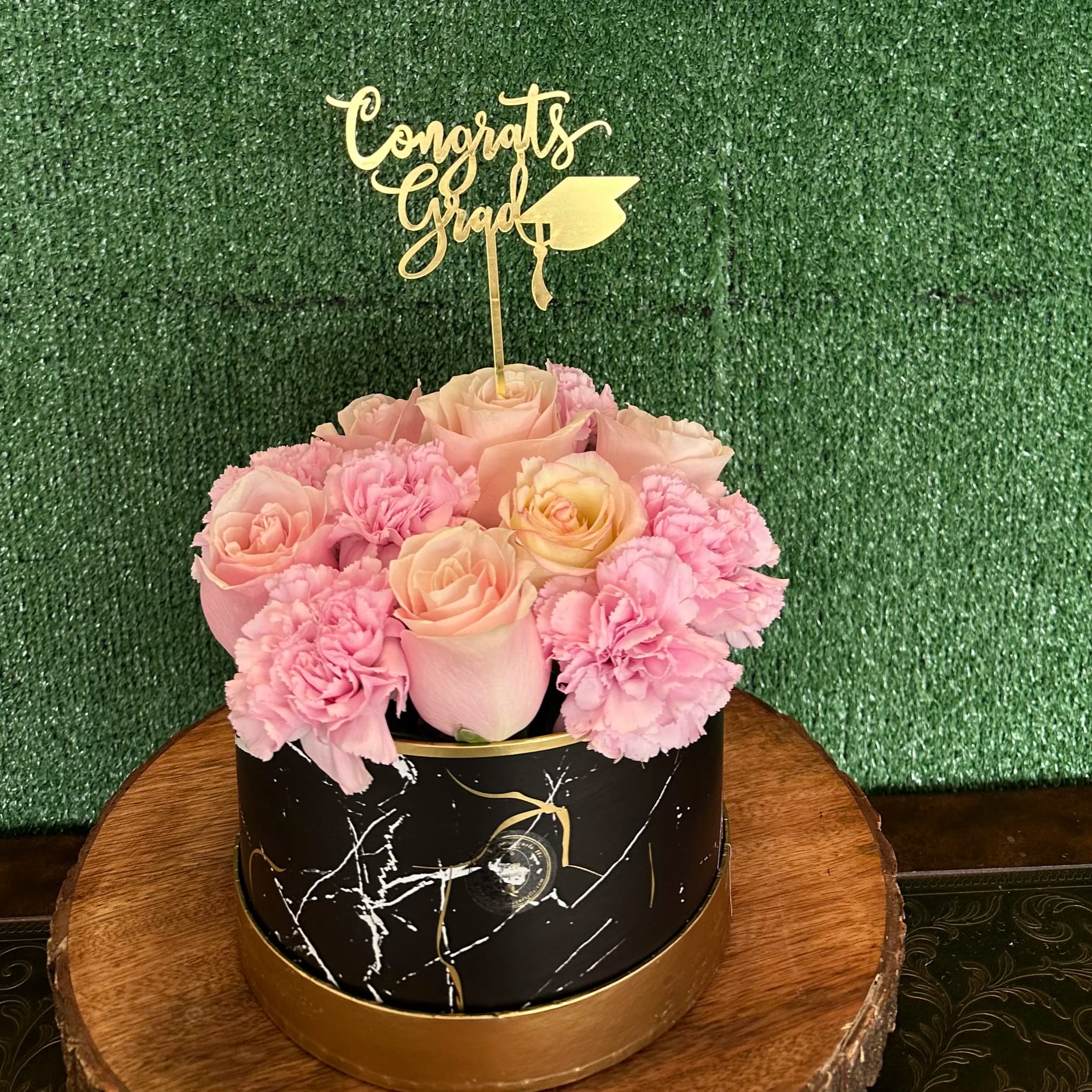 Graduation Bouquet Graduation Bouquet - Flowers in a black box Topper is an add on "Picture is a reference every arrangement would not be exactly the same. Color Substitution may apply. Flowers and color substitution may apply"