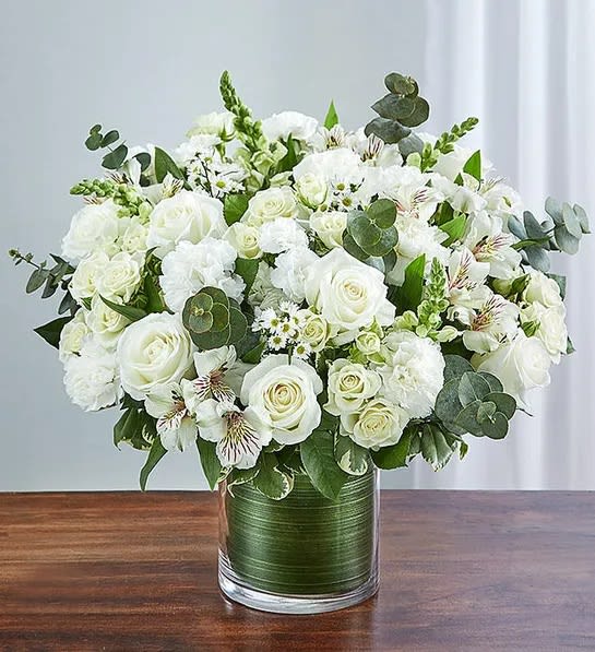 Cherished Memories - All White - Memories are timeless treasures of the heart, meant to be cherished. Our striking, all-white sympathy arrangement of roses, snapdragons, alstroemeria and more, elegantly designed by hand in a graceful cylinder vase, is a touching tribute to a life well lived and the memories that will be held dear forever.