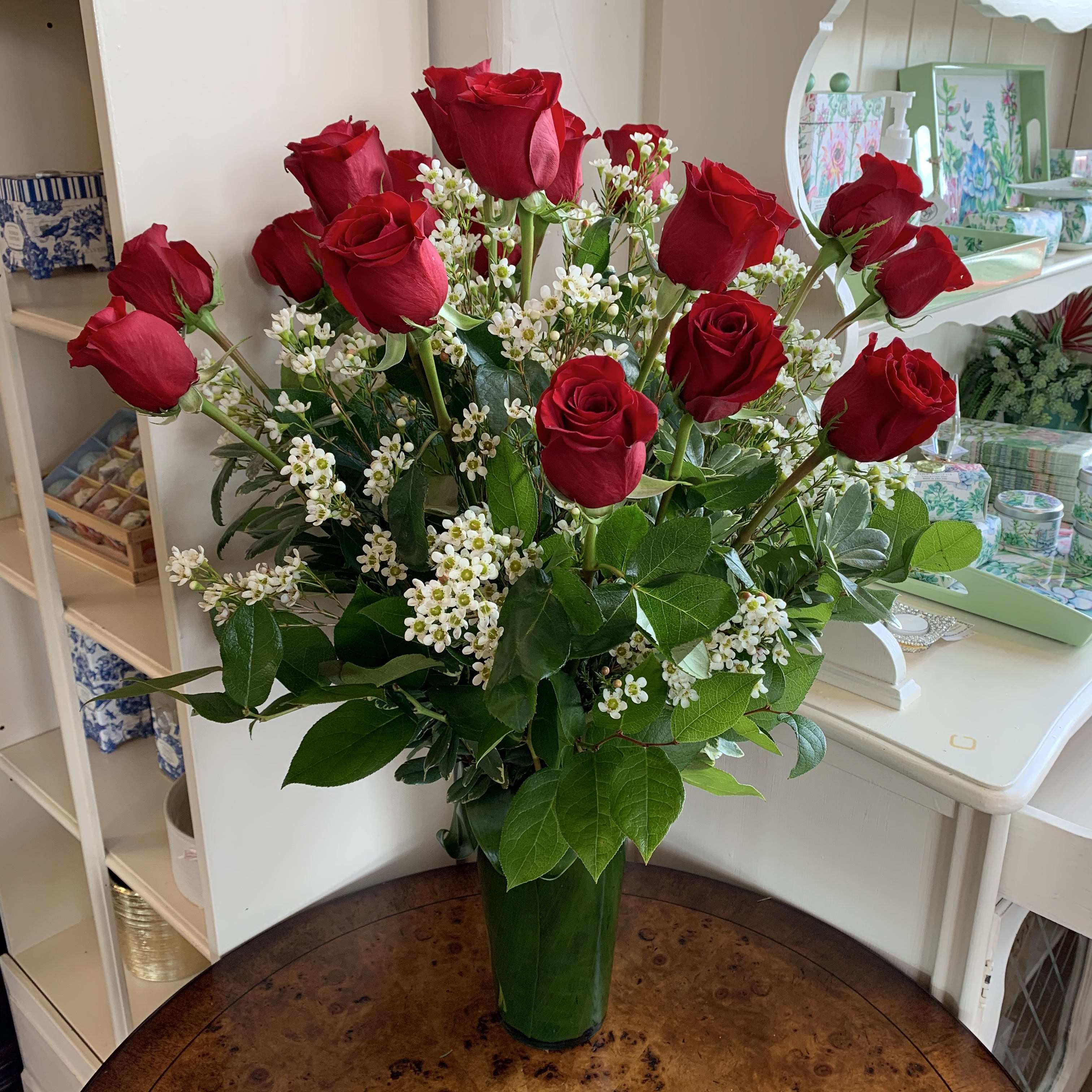 18 Red Rose Bouquet 18 Red Rose Bouquet - 18 long stem red roses arranged in a leaf lined glass vase with premium greens and comlplimenting filler flowers
