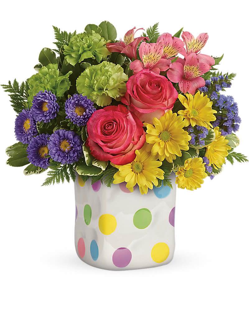 Teleflora's Happy Dots Bouquet Teleflora's Happy Dots Bouquet - Dots what friends are for! Brighten a friend or loved one's spring day with this delightfully dotty gift. Filled with a happy mix of pink, green, purple and yellow blooms, this charming ceramic vase has a fun hand-thrown look and a playful spirit that makes everyone smile! This happy arrangement includes hot pink roses, pink alstroemeria, green carnations, lavender matsumoto asters, yellow daisy spray chrysanthemums, purple sinuata statice, variegated pittosporum and leatherleaf fern. Delivered in a Happy Dots cube.