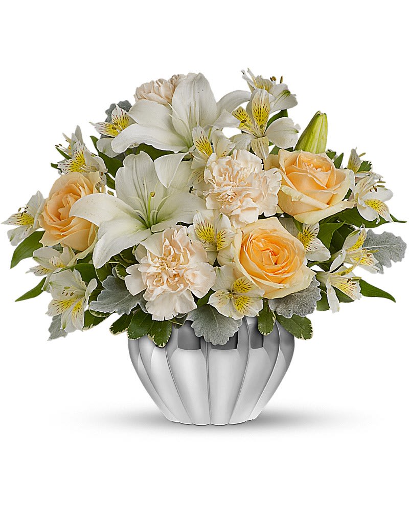 Teleflora's Kiss Me Softly Teleflora's Kiss Me Softly - If you're in the market for a beautiful bargain, this fabulous floral gift is for you. It features lush peach roses, white lilies and other favorites in a gleaming silver Jardiniere vase. So gorgeous, so reasonable, so easy to send. The stylish bouquet includes peach roses, white Asiatic lilies, white alstroemeria and white carnations accented with assorted greenery. Delivered in a silver ribbed Jardiniere vase with a metallized finish.