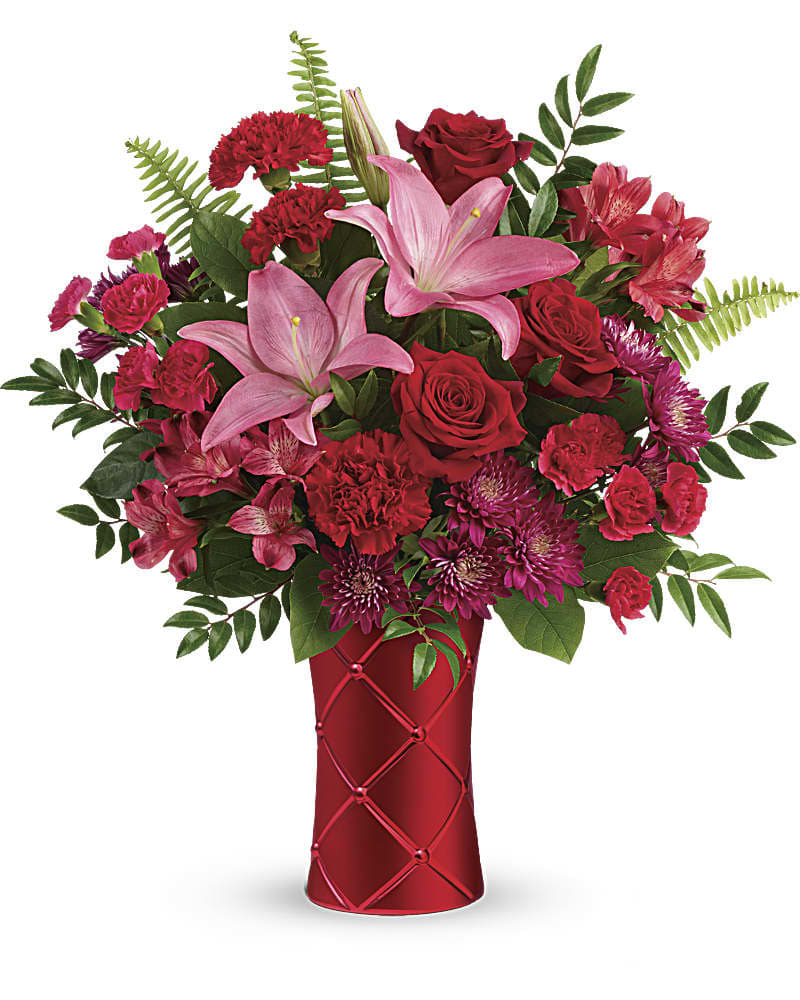 Teleflora's Satin Kisses Bouquet Teleflora's Satin Kisses Bouquet - Send kisses soft as satin with this romantic bouquet! Artfully arranged in a shimmering, satin-finish ceramic vase with pretty quilted texture, this mix of red roses and pink lilies is sure to take their breath away. This bouquet features red roses, pink asiatic lilies, red alstroemeria, red carnations, hot pink miniature carnations, purple cushion spray chrysanthemums, huckleberry, sword fern, and lemon leaf. Delivered in a Sweetest Satin Vase.