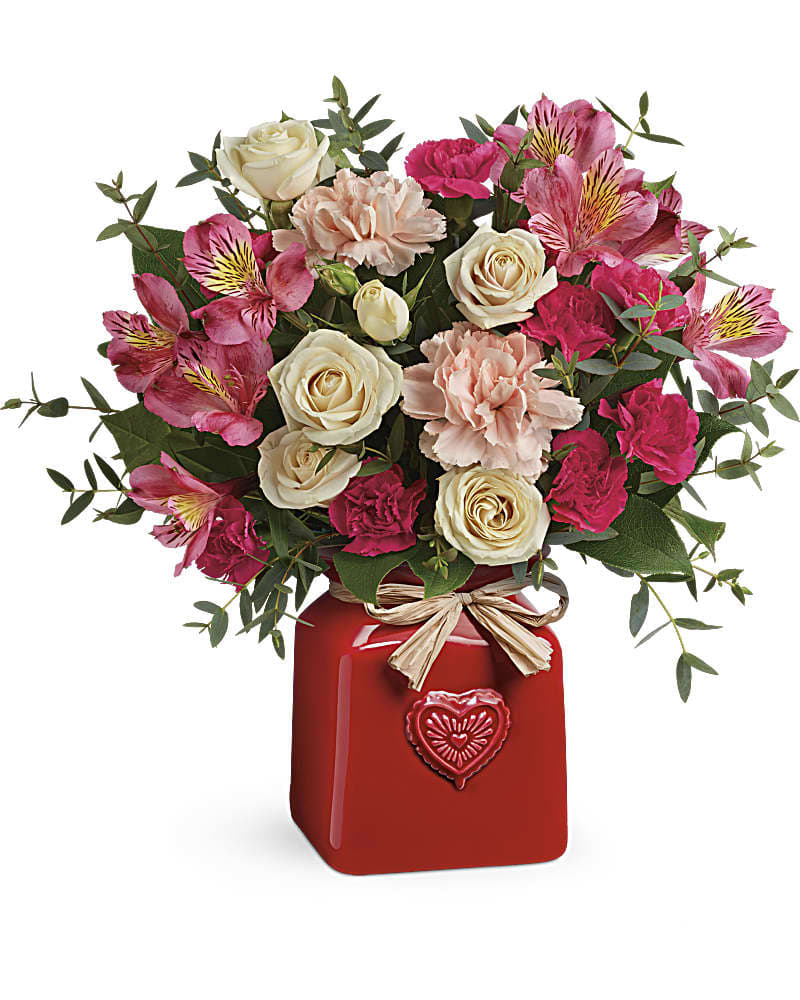 Teleflora's Vintage Heart Bouquet Teleflora's Vintage Heart Bouquet - This country-chic surprise steals everyone's heart! Its creamy roses, red alstroemeria and peach carnations get a cute farmhouse feel when arranged in this adorable ceramic crock with embossed heart and Italian raffia bow! Crème roses, red alstroemeria, peach carnations and hot pink miniature carnations are accented with parvifolia eucalyptus and lemon leaf. Delivered in a Country Sweetheart Crock.