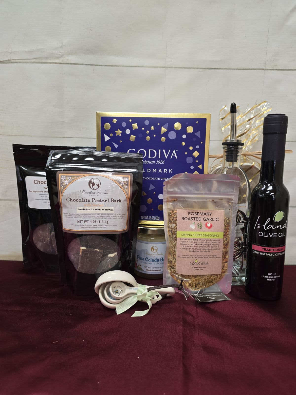 Deluxe Gourmet basket (Valued at over $130) - This fun Deluxe Gourmet basket normally contains the following:  1 - IOO Flavored Oil or Vinegar  1 - Oil Bottle 1 - IOO Dipping Blend 1 - HPC Fruit Jam 7.5oz (sub 7.5oz Fruit Butter) 1 - Measuring Spoon 2 - HPC Chocolate Almond or Pretzel Cluster 1 - IOO Brownie Kit 1 - 9pc Godiva Goldmark Gift Box 