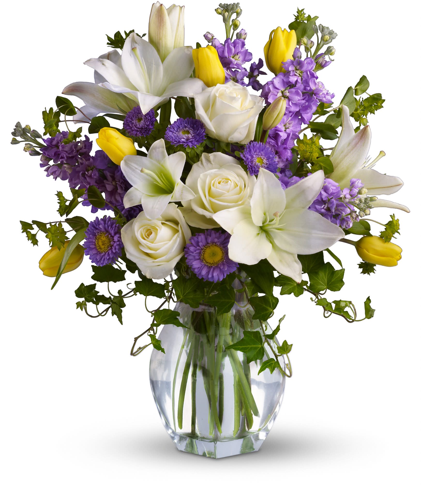 Spring Waltz - Graceful, elegant and timeless, this beautiful spring bouquet offers up colors, blossoms and textures in perfect harmony.     Serene crÃ¨me roses, yellow tulips, white asiatic lilies, lavender stock and matsumoto asters are perfectly arranged with spring's freshest greenery and delivered in a lovely clear glass vase. Send it and you'll definitely waltz right in to someone's good graces! Approximately 17 1/2&quot; W x 20&quot; H 