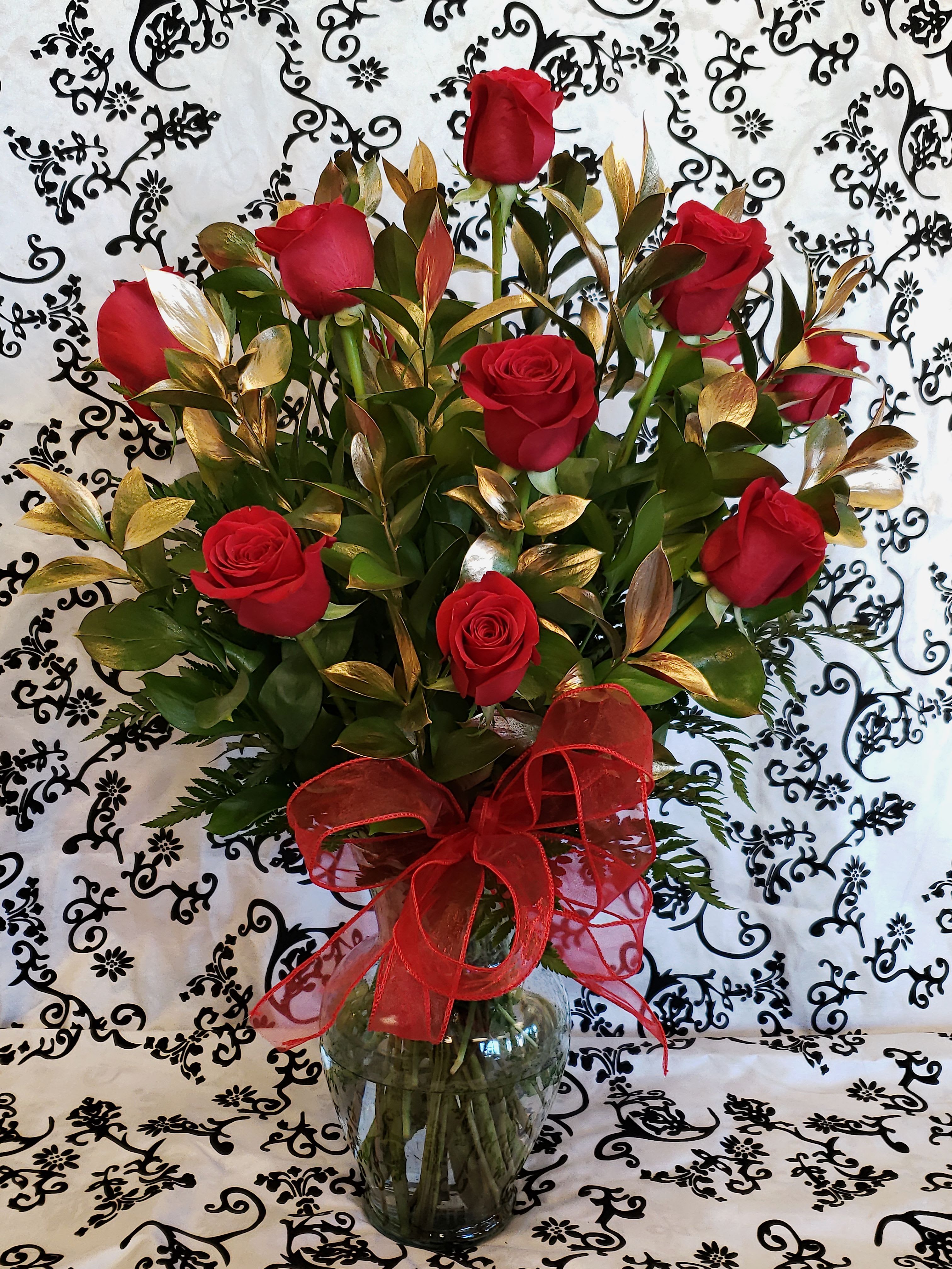 12 RED ROSES MODERN LOOK 12 RED ROSES MODERN LOOK - 12 red roses with a green filler with a gold ruscus note: Note: Deluxe price includes 18 roses Note: Premium price includes 24 roses