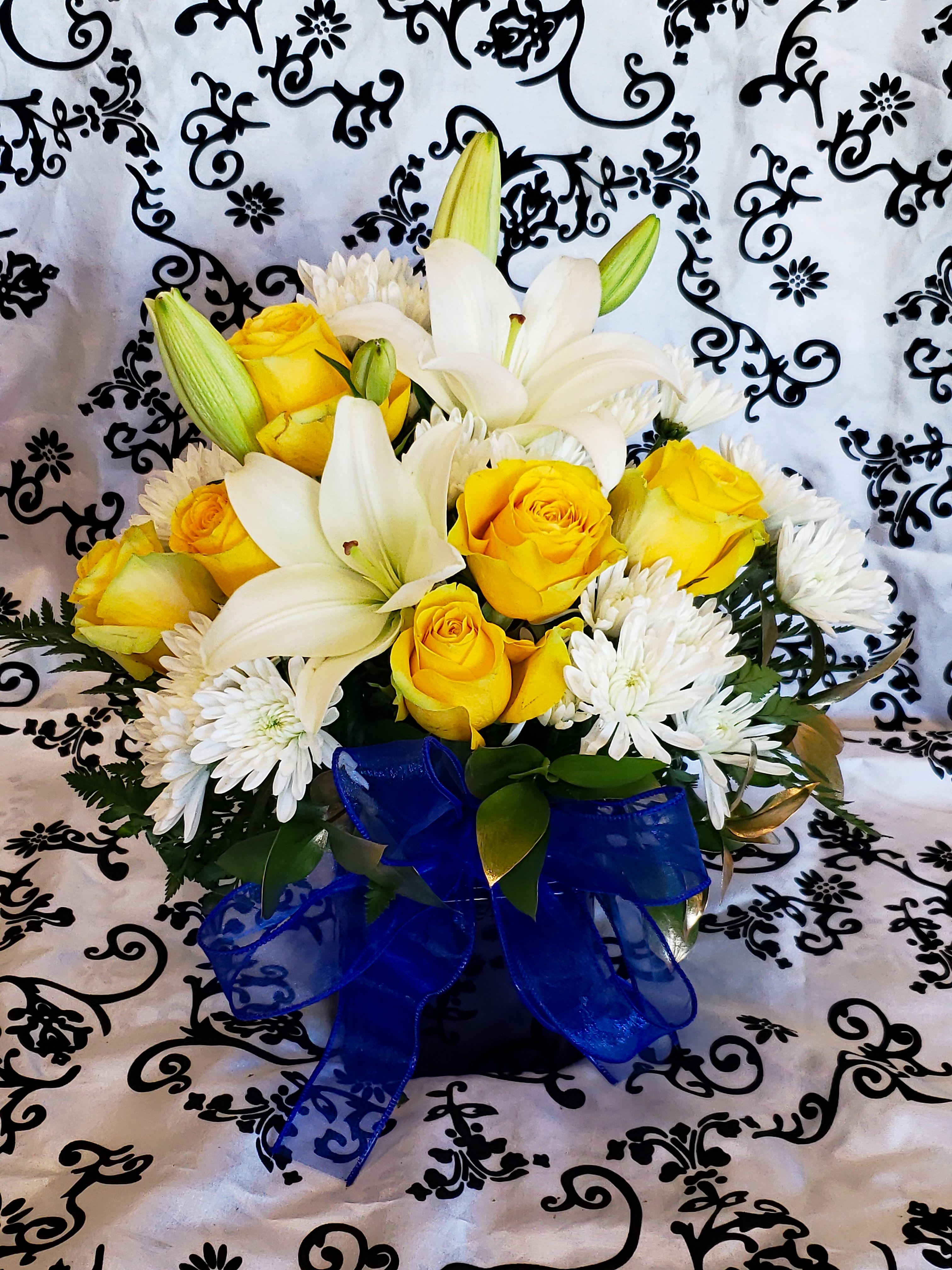 WHITE & YELLOW CUBE WHITE & YELLOW CUBE - A mixture of white and yellow flowers such as carnations, roses, lilies and cushion. Designer choice cube with this tone of colors.