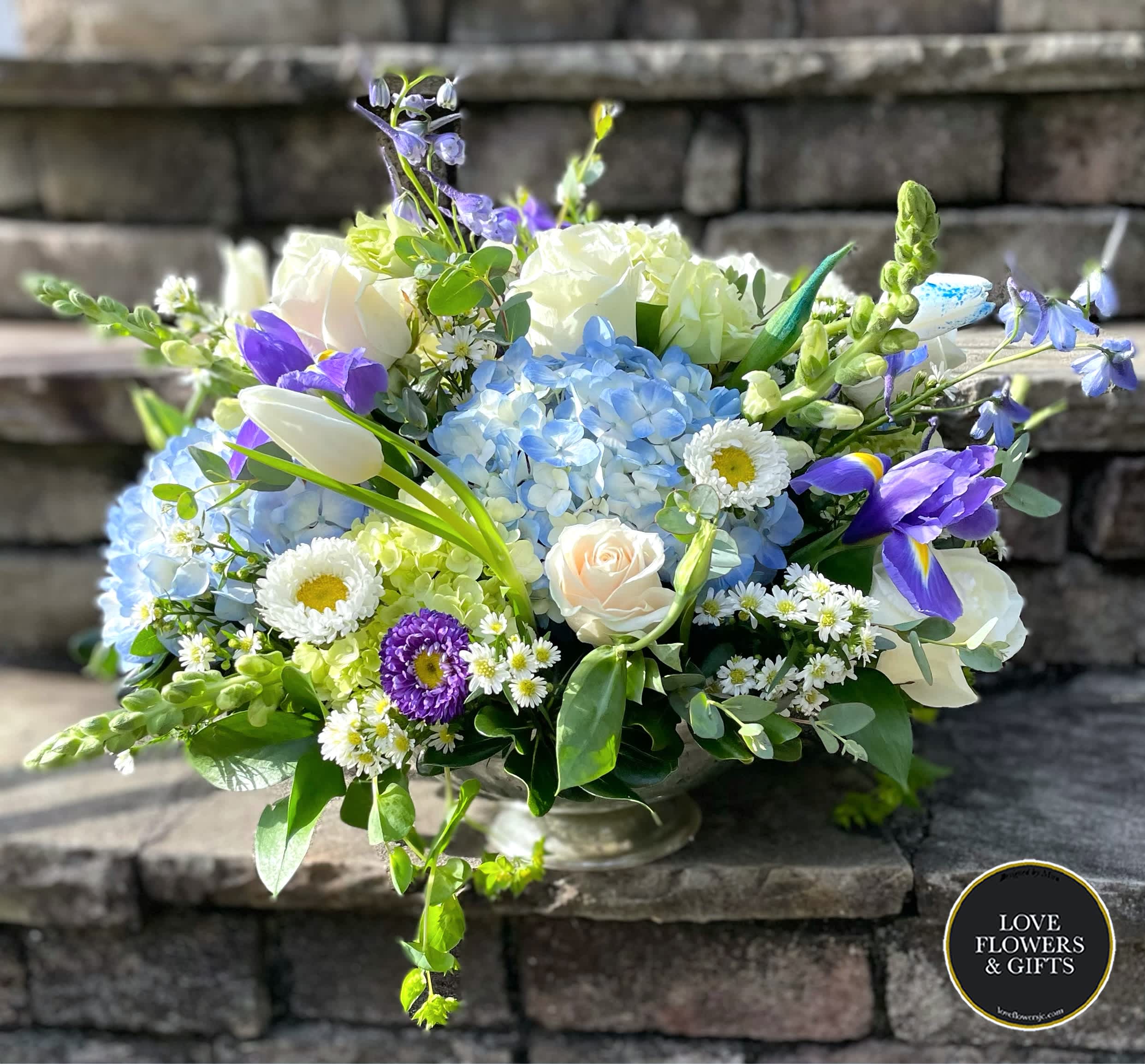 Royal Blues  - A large centerpiece made of blues and whites of roses, hydrangeas, iris, delphinium and more, designed in centerpiece bowl Perfect springtime gathering and party piece. 