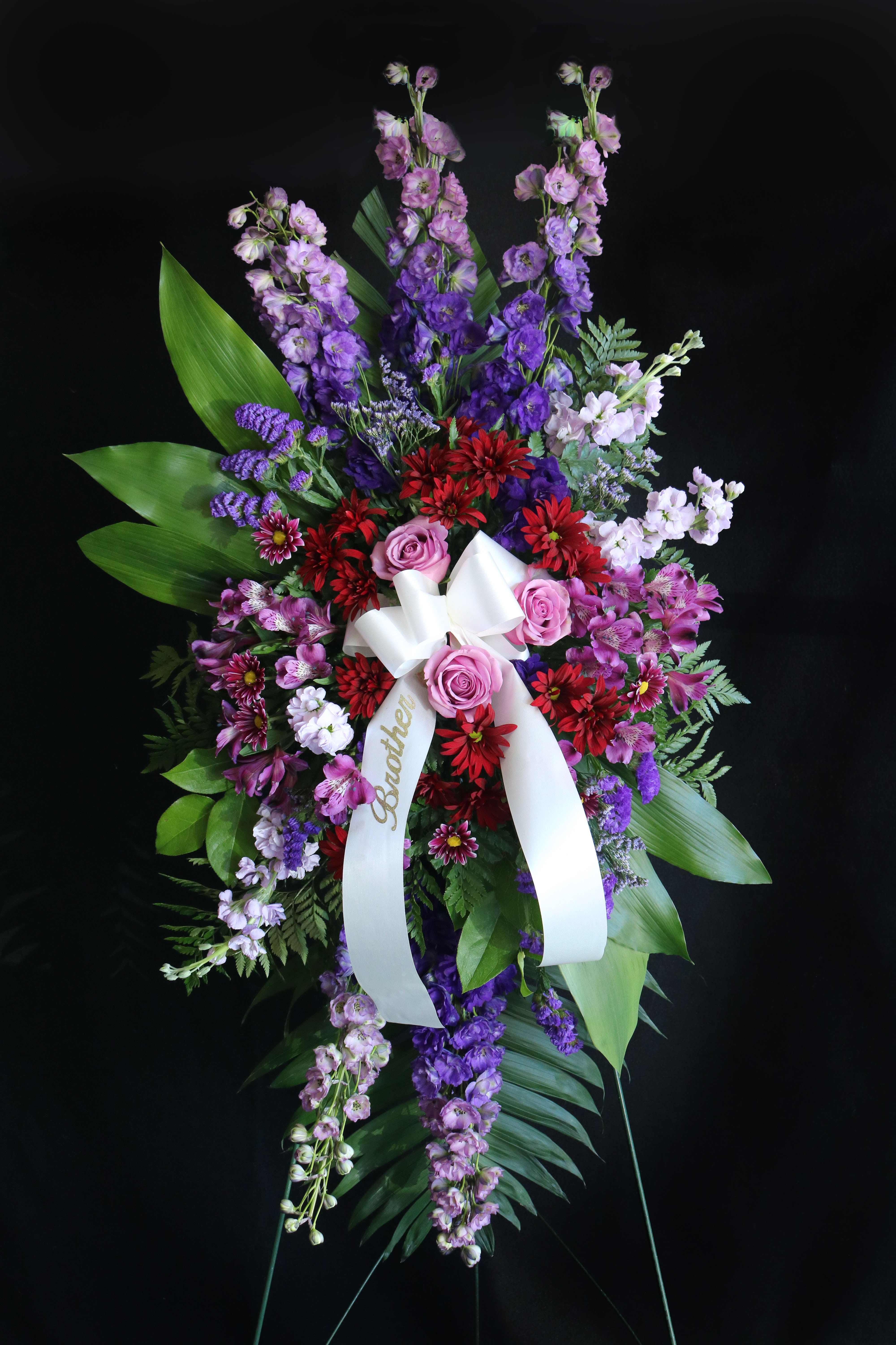 Shades of Purple Spray Shades of Purple Spray - an array of purple and lavender flowers with a splash of red daisies. ribbon optional