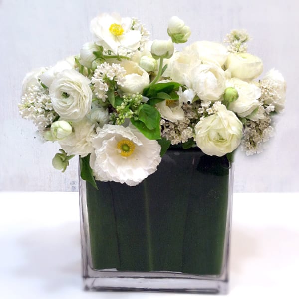 Simply Chic Simply Chic - An arrangement with white seasonal flowers, featuring ranunculus and garden roses. 14 inches tall and 10 inches wide. *Each bouquet is unique and ingredients may vary slightly.