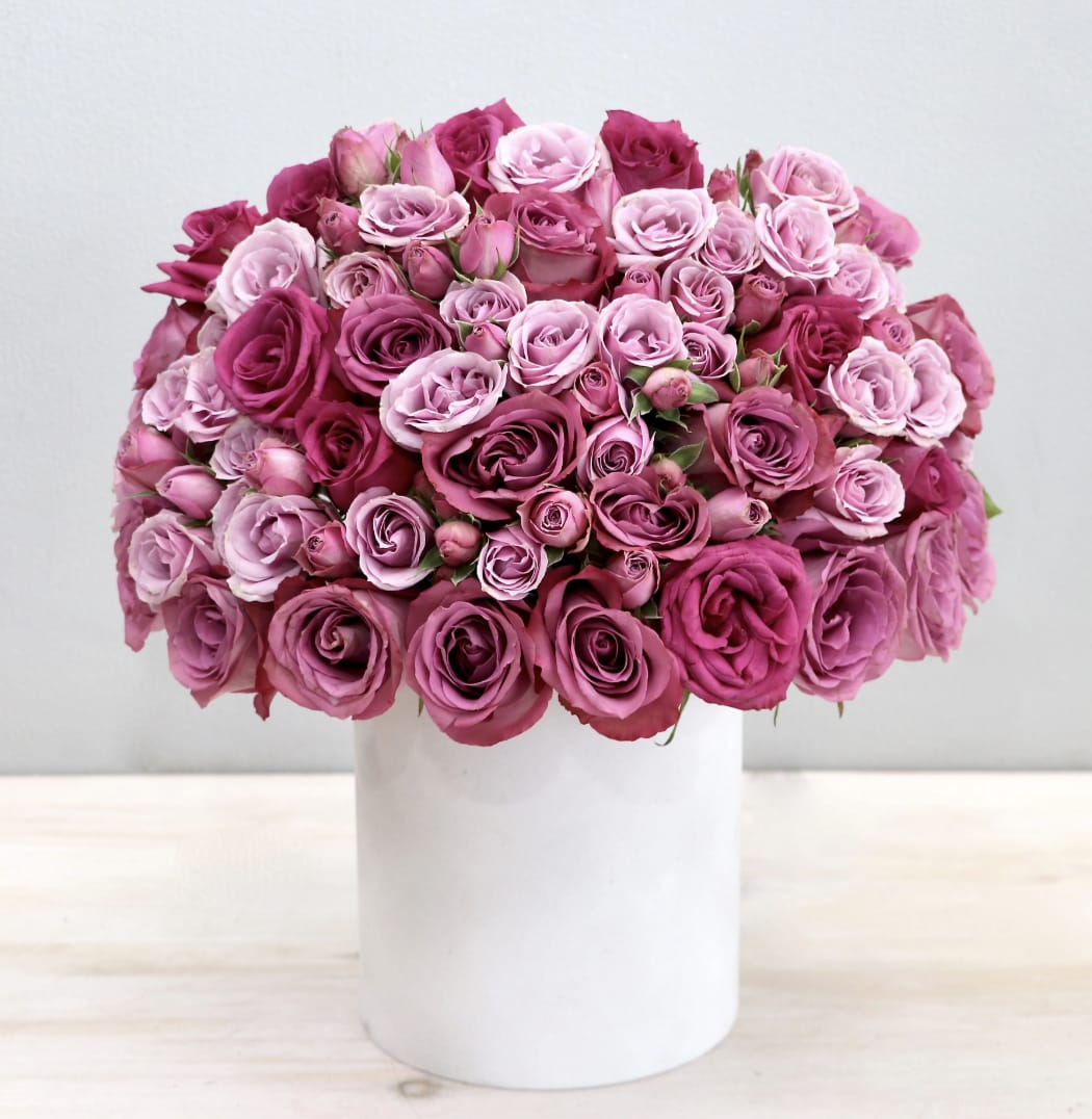 Purple Haze Hat Box - WeHo Purple Haze Hat Box - WeHo - This hatbox contains a mix of purple roses with spray roses in a white hatbox. The photo shown is in the standard size.