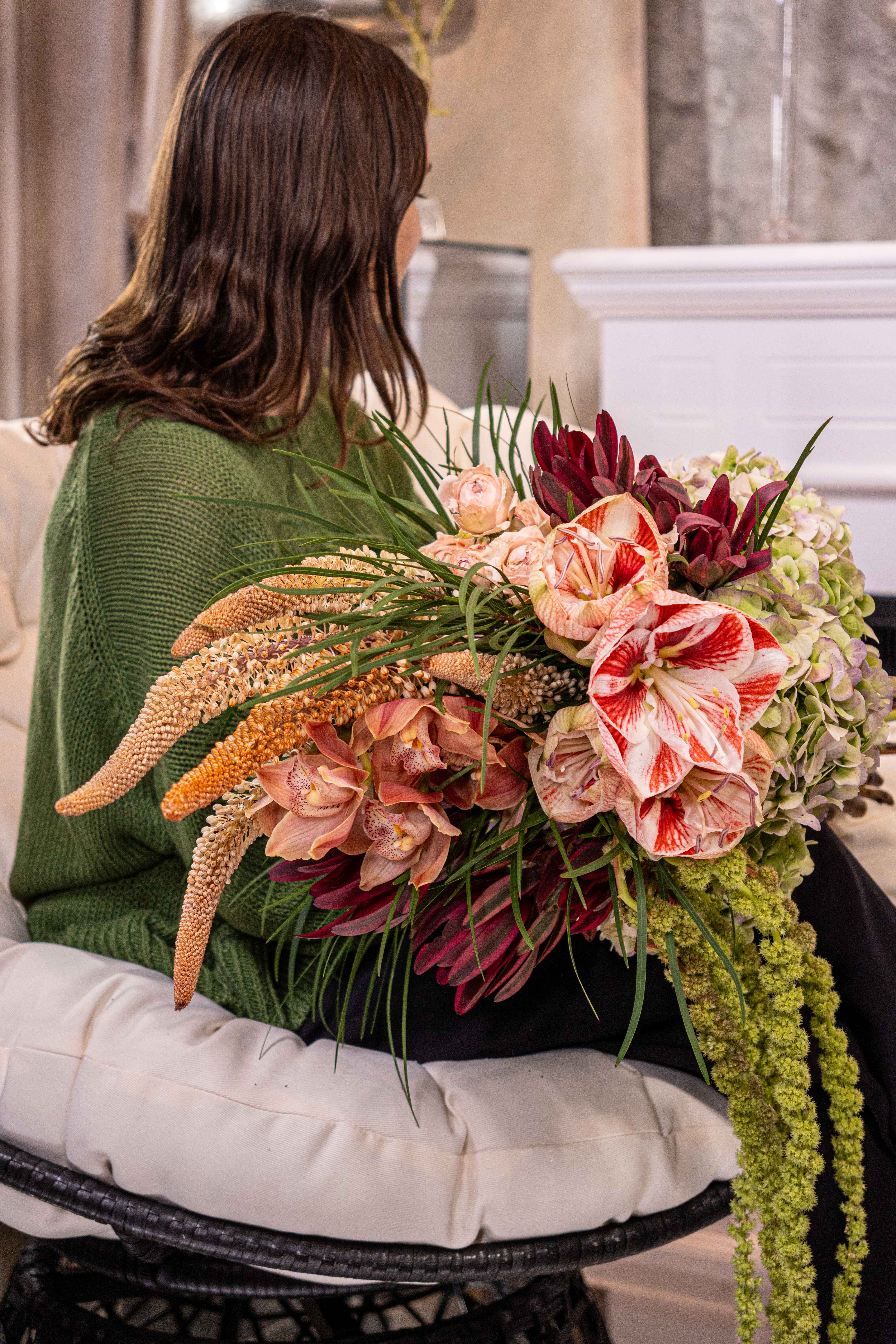 №210 Ethereal Elegance - This stylish bouquet presents a luxurious and graceful combination of unique flowers, blending bold and delicate elements to create an otherworldly yet refined aesthetic. The arrangement evokes a sense of both strength and beauty with its contrasting textures and flowing greenery. The dynamic interplay between striking red blooms and intricate dark foliage embodies elegance and passion, making it a perfect choice for those looking to make a sophisticated statement.