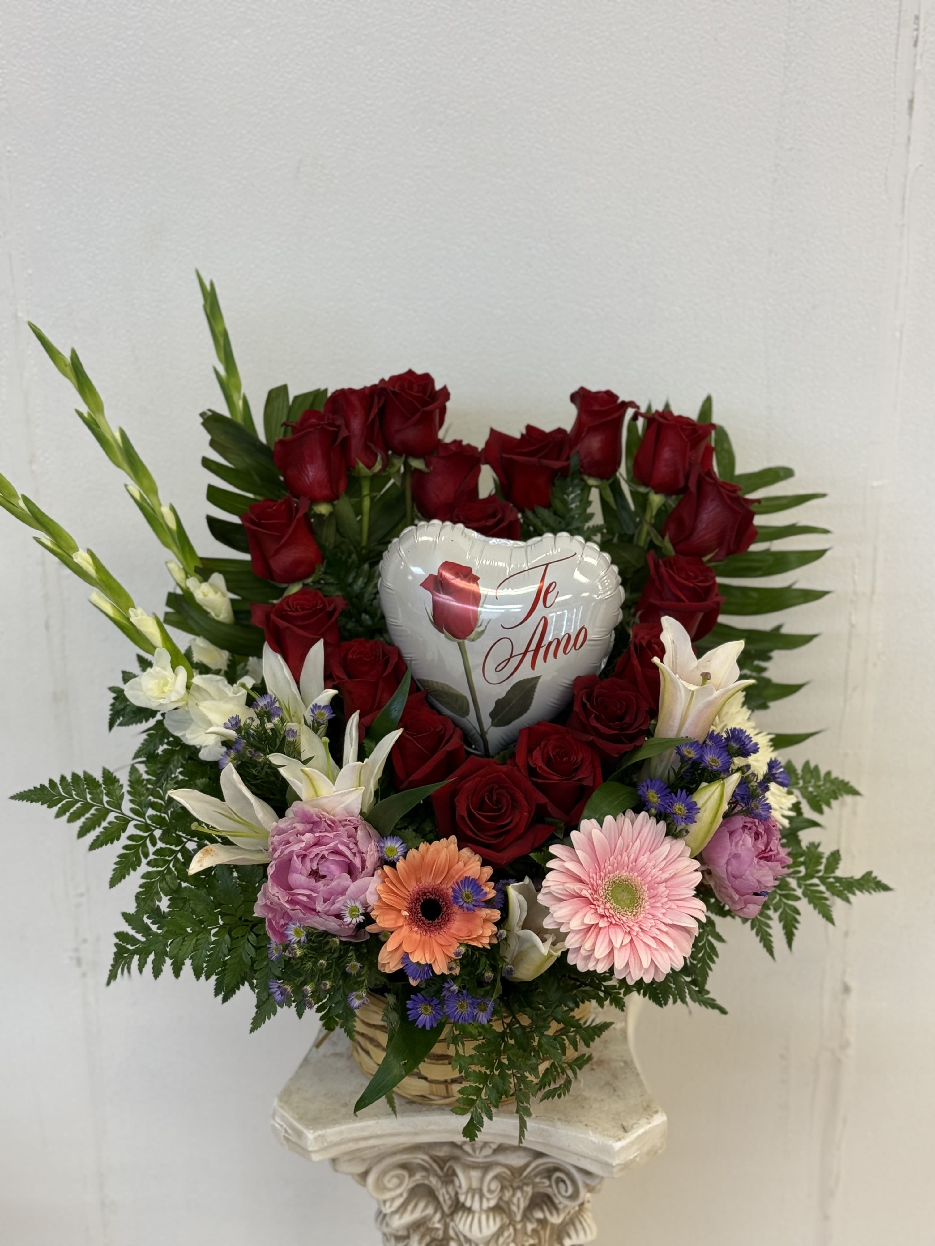 Heart Shaped Arrangement Heart Shaped Arrangement - Heart shaped arrangement with red roses, paired with a mixture of spring colorful filler flowers at the bottom.