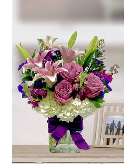 Summer 10 Summer 10 - Lavender roses with hydrangeas and lilies in a clear glass vase With a festive bow And same day of delivery for Tulsa flowers