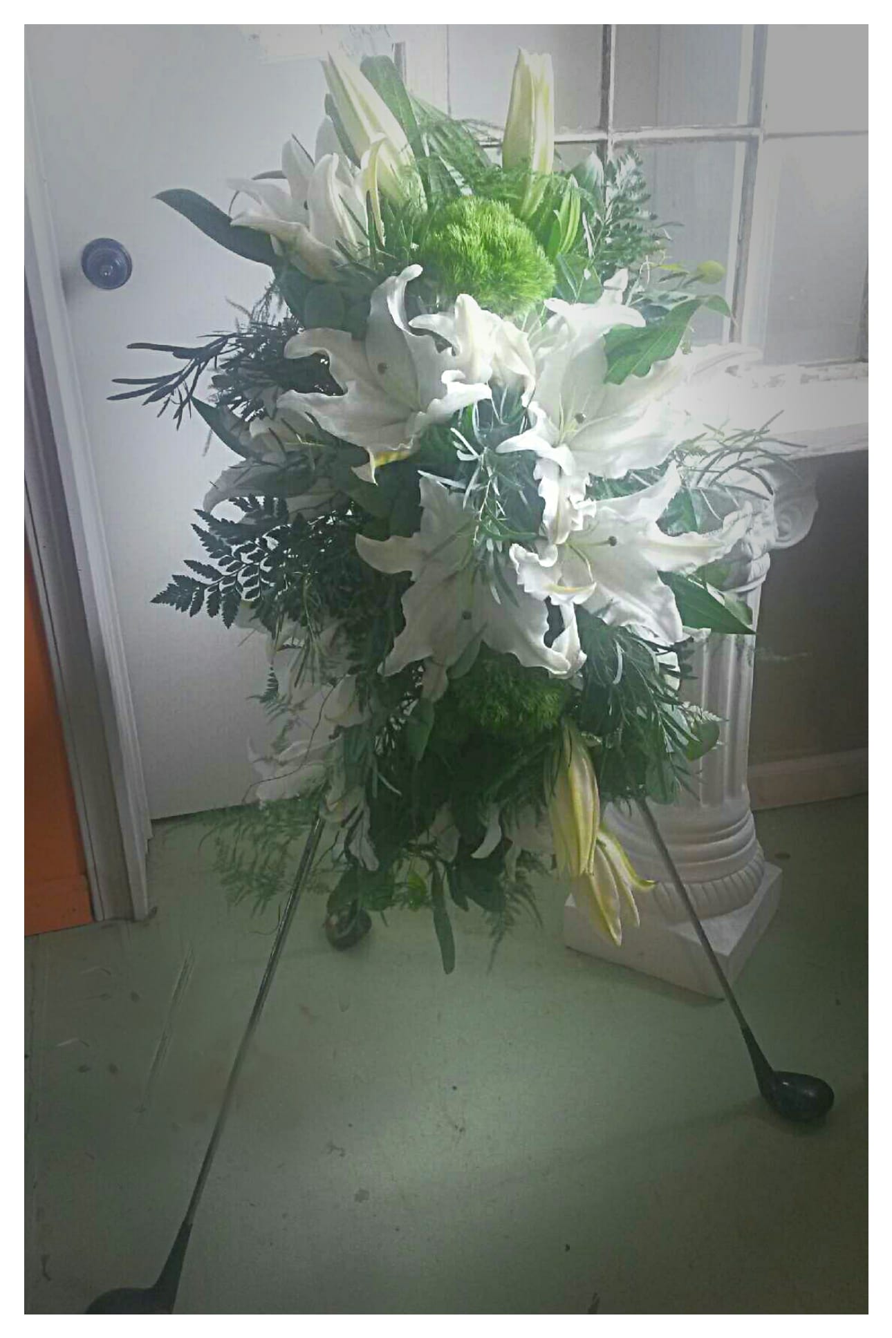 On the Green - Standing spray of white lilies and filler........ constructed with golf clubs.