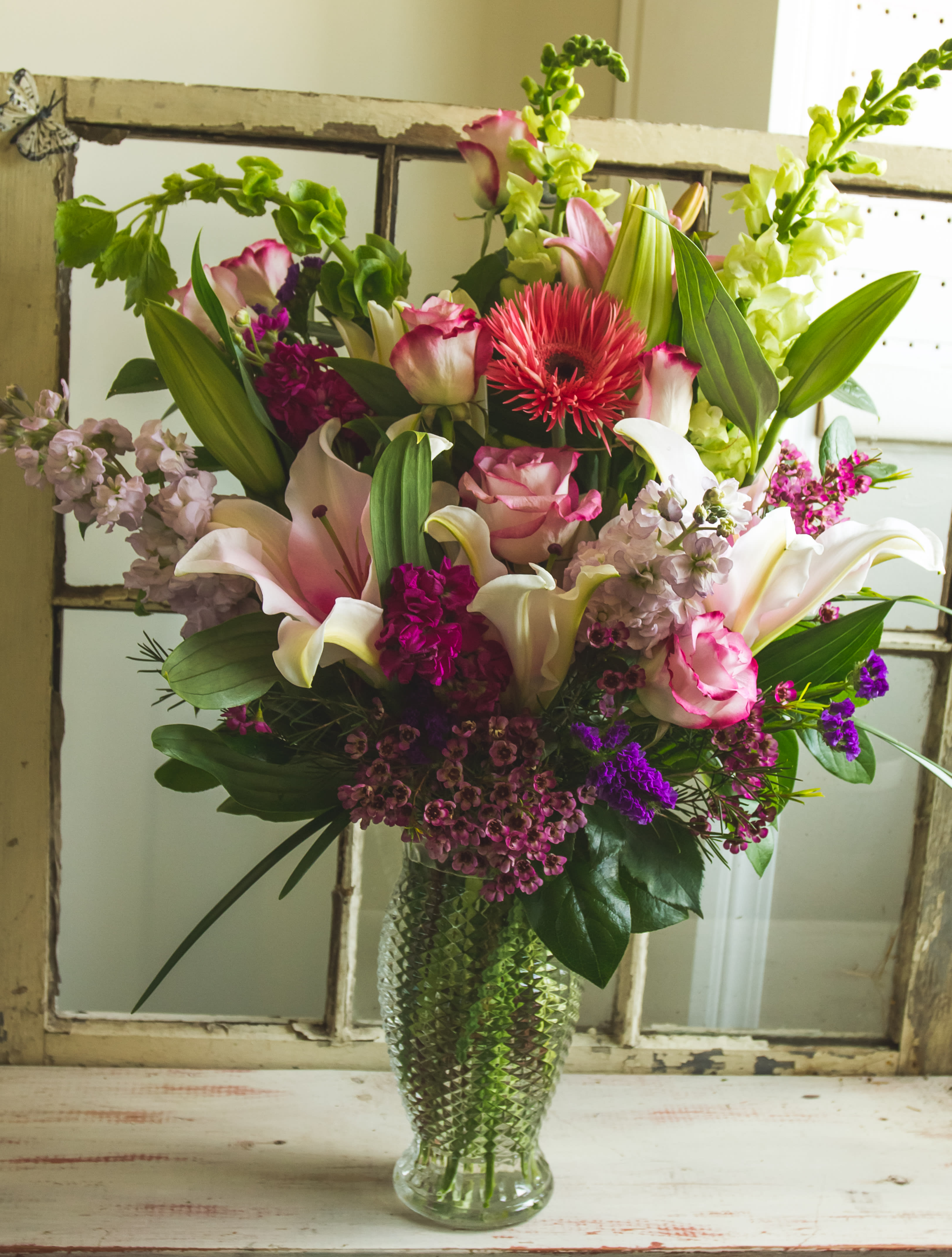 Symphony of Blooms - A lovely mix of Stock, Roses, and lilies with filler in a vase. 