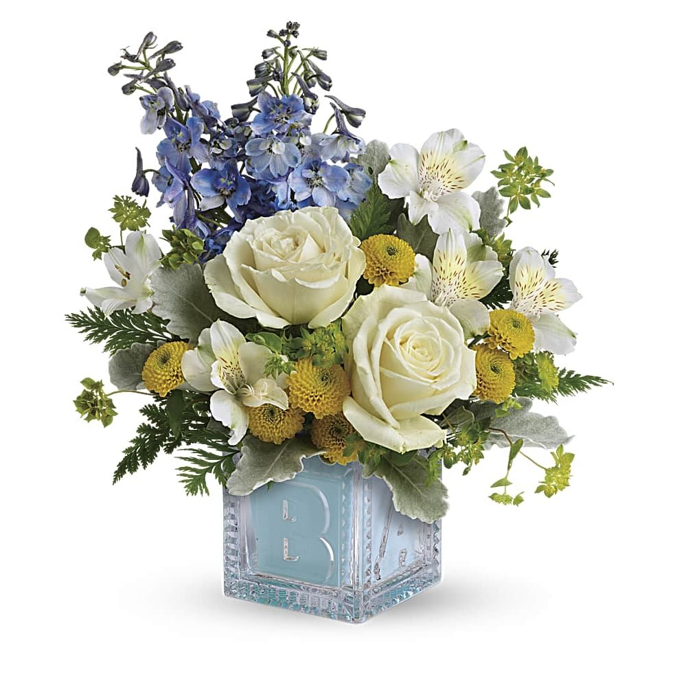 Welcome Little One Bouquet - Welcome the new addition with a charming glass baby block keepsake, bursting with a sweet bouquet of roses, mums and delphinium. White roses, white alstroemeria, yellow button spray chrysanthemums, and blue delphinium are arranged with bupleurum, dusty miller, and leatherleaf fern. Delivered in a Baby Block.
