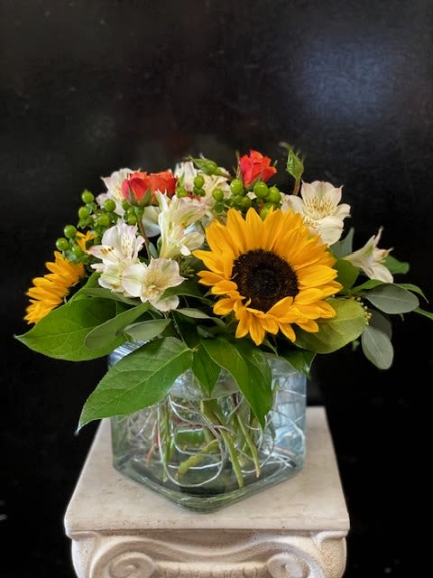 Happy Days - A cheerful square glass vased arrangement featuring Sunflowers, Spray Roses, Alstromeria, and Hypericum.