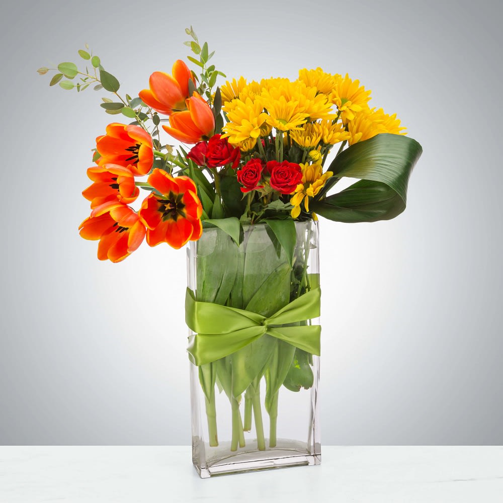 Make it Cozy by BloomNation™ - An elegant arrangement featuring daisy mums, tulips, and spray roses with a ribbon-wrapped vase, this arrangement would be a great gift for any occasion. Great for Mother's Day, Easter, Spring, Birthday, Thank you, or any special occasion.   DETAILS Yellow daisy mums, orange tulips, coral orange spray roses and greenery.  FLORIST-TO-DOOR Same day flower delivery on most orders placed online by 12 pm or 10 am on weekends PST.  VASE INCLUDED Orientation: One-Sided Item #NF-1335  BLOOM DETAILS Tulips Spray Roses Daisy-Mums Greenery  The Standard Arrangement is approximately 12&quot; W x 16&quot; H. (SHOWN) The Deluxe Arrangement is approximately 12.5&quot; W x 16.5&quot; H. The Premium Arrangement is approximately 13&quot; W x 17&quot; H.  How to place an order? 1. You can place an order directly on this secure website OR 2. You can call in your order by dialing: (323) 262 - 9238 OR 3. You can visit our store (appointment recommended 323.262.9238)  NINFA'S FLOWERS 2405 WHITTIER BLVD. LOS ANGELES, CA. 90023  ATTENTION: *Please note that on busy holidays, Valentine's Day, and Mother's Day, we cannot verify if the recipient received the flowers until the following day. You can verify delivery on the website after 10:00 pm, call 323.262.9238 the following day after 10:00 am, or contact the recipient directly. Thank you for your patience and understanding.