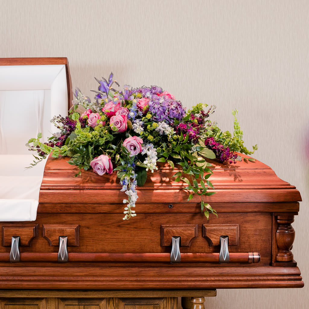 Believe - A stylish casket spray in a palette of cool colors is reminiscent of walking in the cool of the garden.  *Please allow three business days prior to the service to order specialty flowers included in this arrangement*