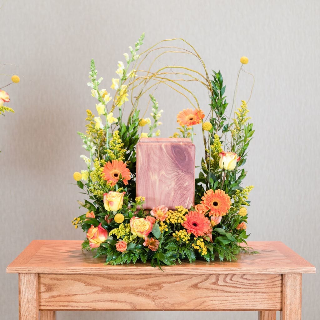 Dawn - A mix of orange gerbera daisies, yellow snapdragons and yellow roses used to create a striking frame around an urn.  Approximate Dimensions: 28&quot;T X 20&quot; W