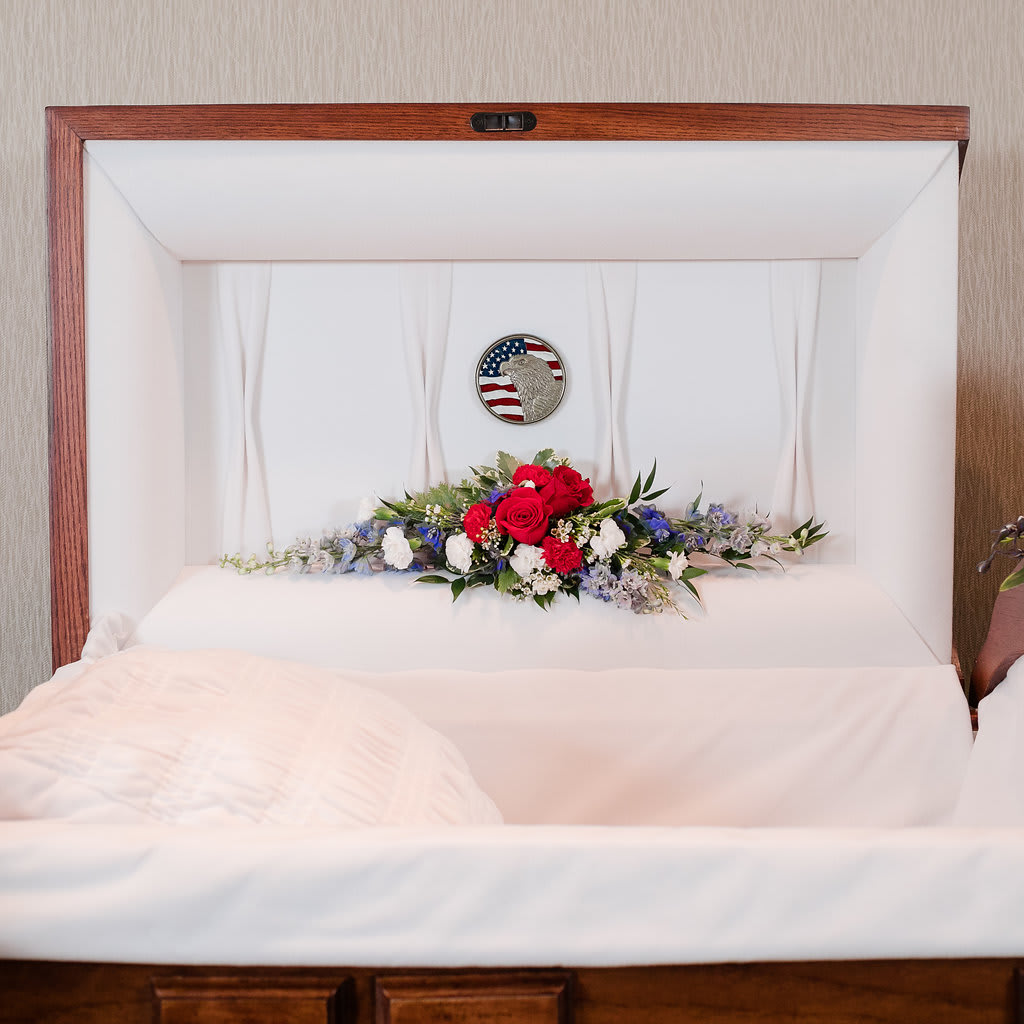 Emblem - Red, White and Blue blossoms to line the lid of the casket in honor of one who served.