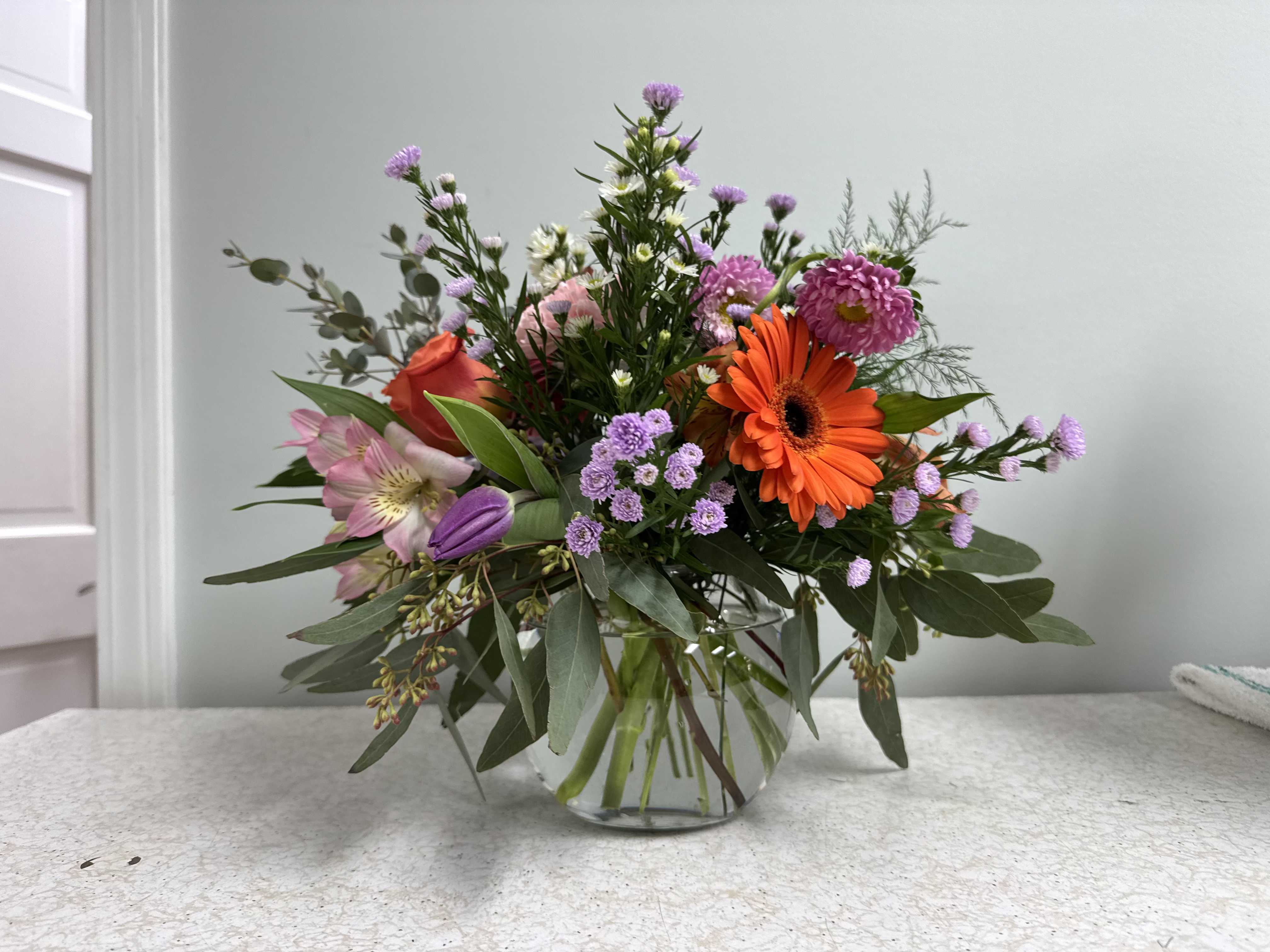 Spring Fling Spring Fling - A bowl of spring colors, blooms, and movement that will delight anyone! Tulips, gerbera daisies, eucalyptus, alstromeria, and other seasonal blooms will be in the orange-peach-lavender realm, or feel free to ask for any color palette.