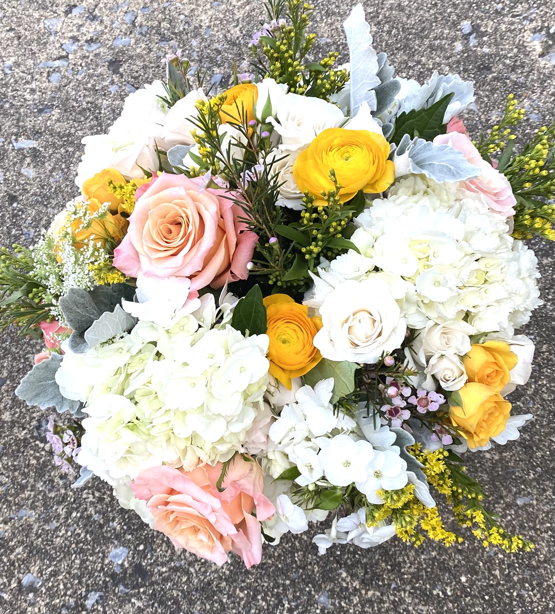 Bouquet of spring flowers - Peach roses, hydrangeas, solidago and other flowers in clear glass vase