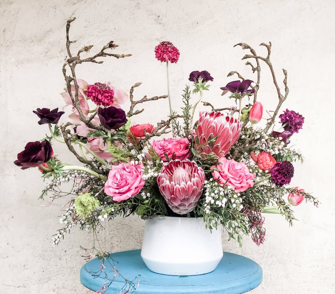 Glastonbury  - This stylized floral arrangement features gorgeous shades of pink and deep purples. Designed in a high end vase and designed with florals from our very own garden, this collection is perfect for any occasion!  Flowers and greenery may vary due to seasonal availability, but that’s part of the charm! Our creative designers will substitute with the freshest high end product available- some grown in our very own garden!- and create something beautiful.  *Have a special request?* Let us know in the special instructions section during checkout.