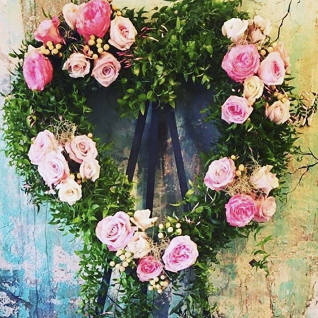 Pink Memorial Heart - Smilax greenery with roses, spray roses, and garden roses on an easel (included). Round wreath shape can be requested in notes as well as color preference. 