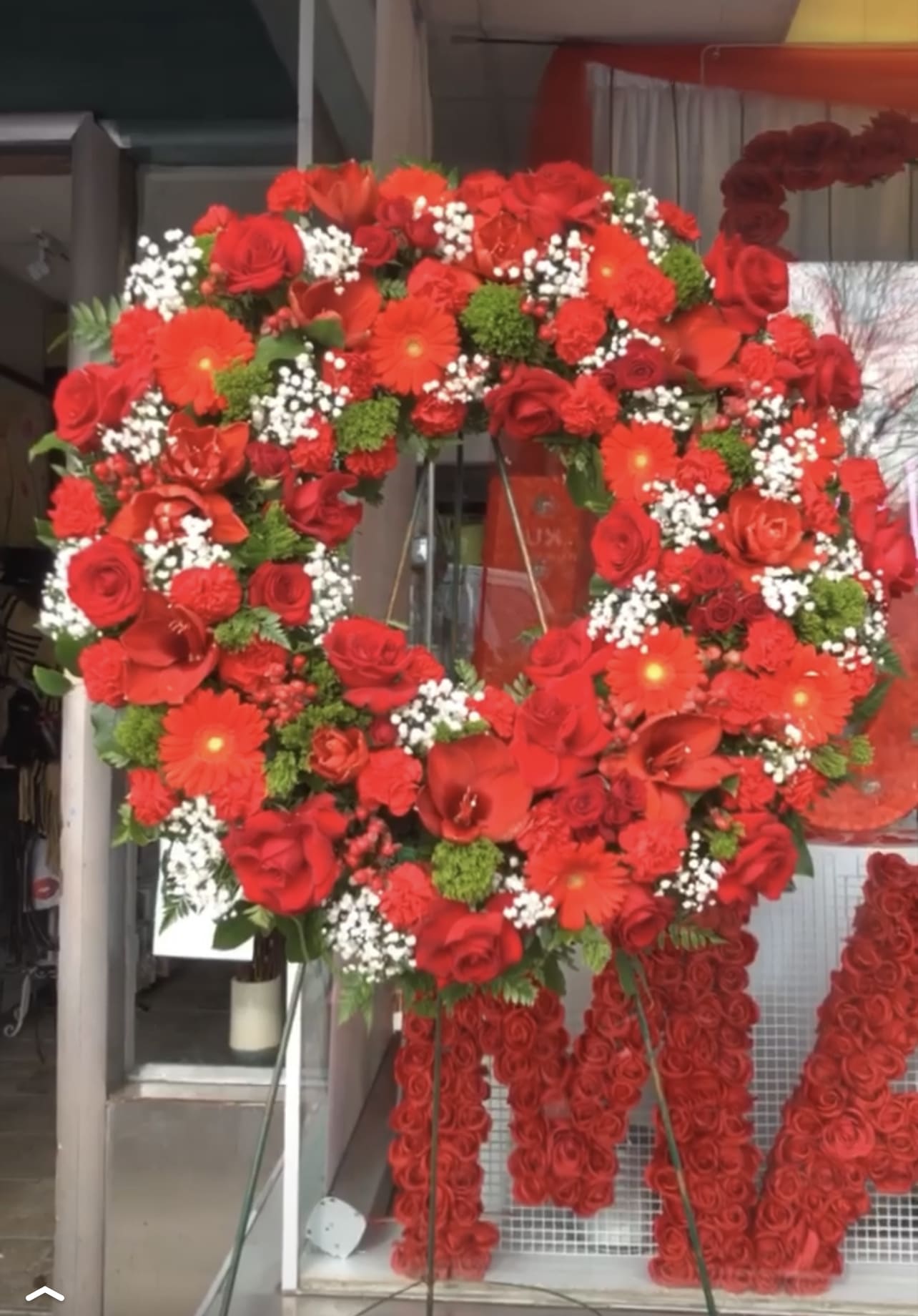 RED FUNERAL WREATH RED FUNERAL WREATH - We have design this beautiful wreath with gerber ,red roses some green triclinium we custom design ribbons as you request !