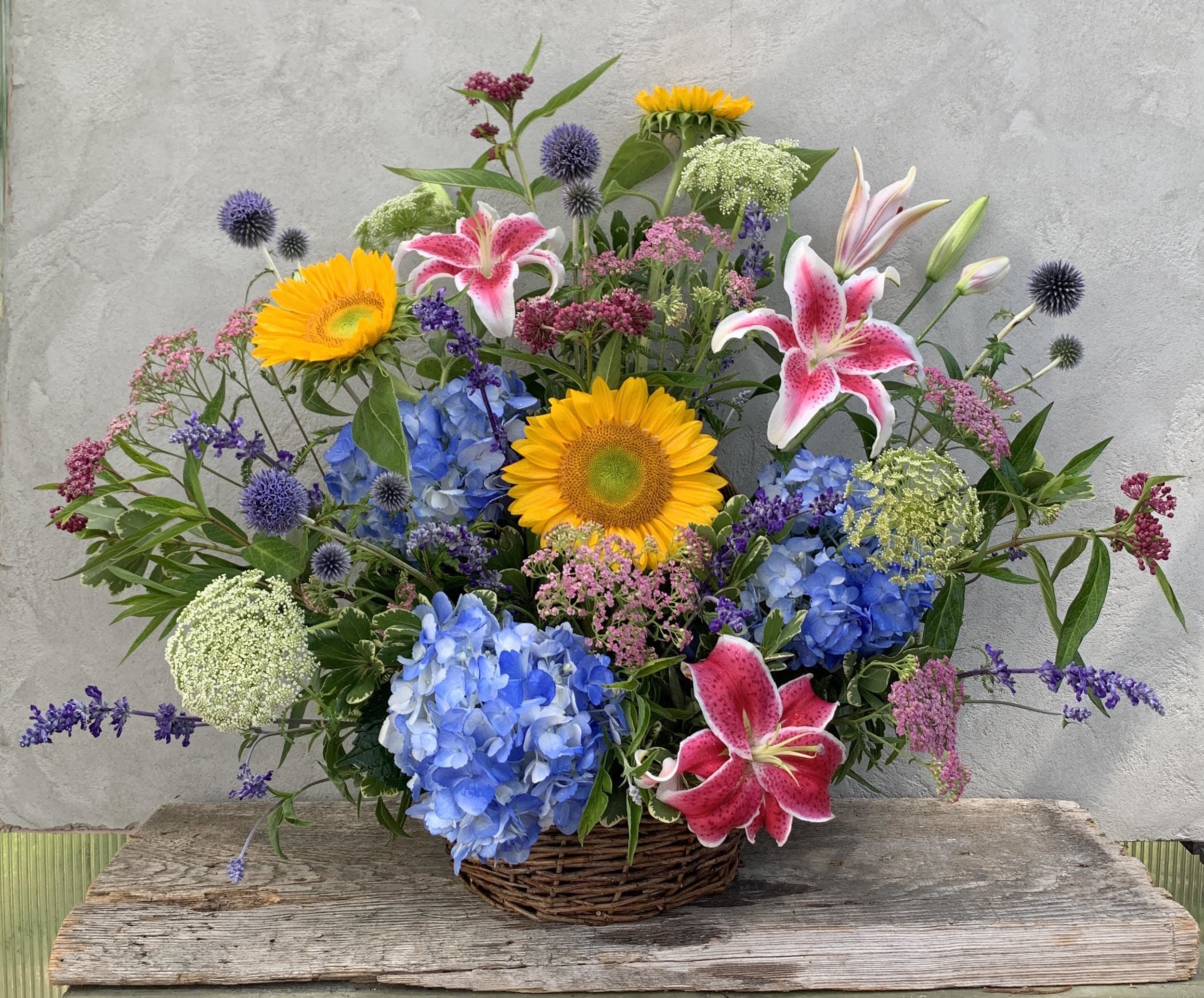 Summer Sympathy Basket Summer Sympathy Basket - A traditional one sided arrangement of mixed summer flowers. Approximately 24" high. Flowers and colors may vary depending on availability.