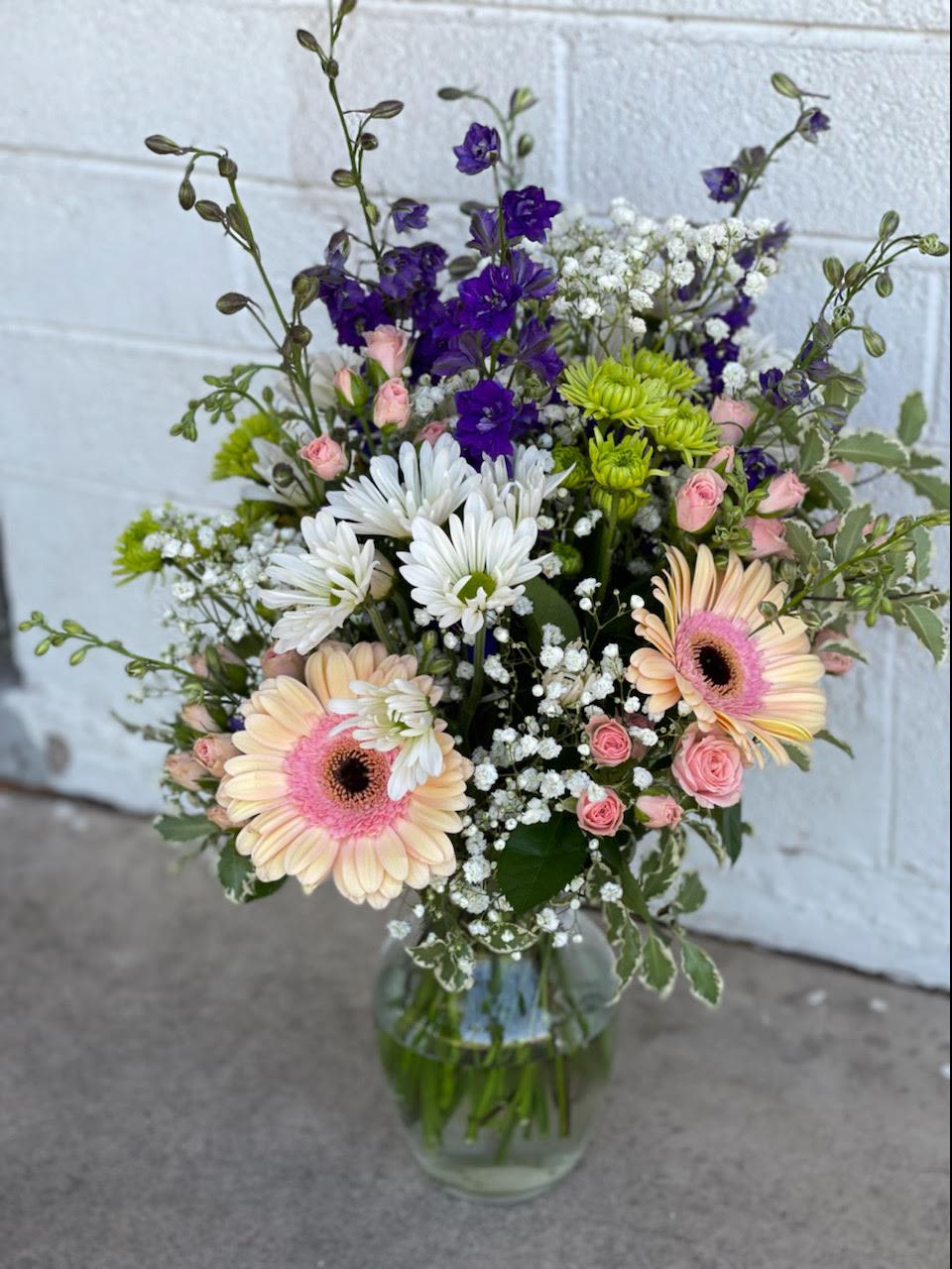 Precious by Blooming Canyon  - A serene floral arrangement, this design features delicate shades of soft pink, pure white, and elegant purples, all beautifully arranged in a clear vase. The gentle color palette creates a calming and graceful atmosphere, making it the perfect gift. With its timeless beauty, this arrangement adds a touch of softness to any room or occasion. 