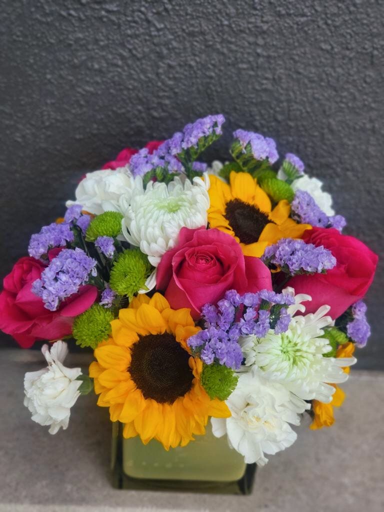 Bubbly Bloom - What could brighten someone’s day more than this bubbly vibrant arrangement featuring sunflowers and roses.