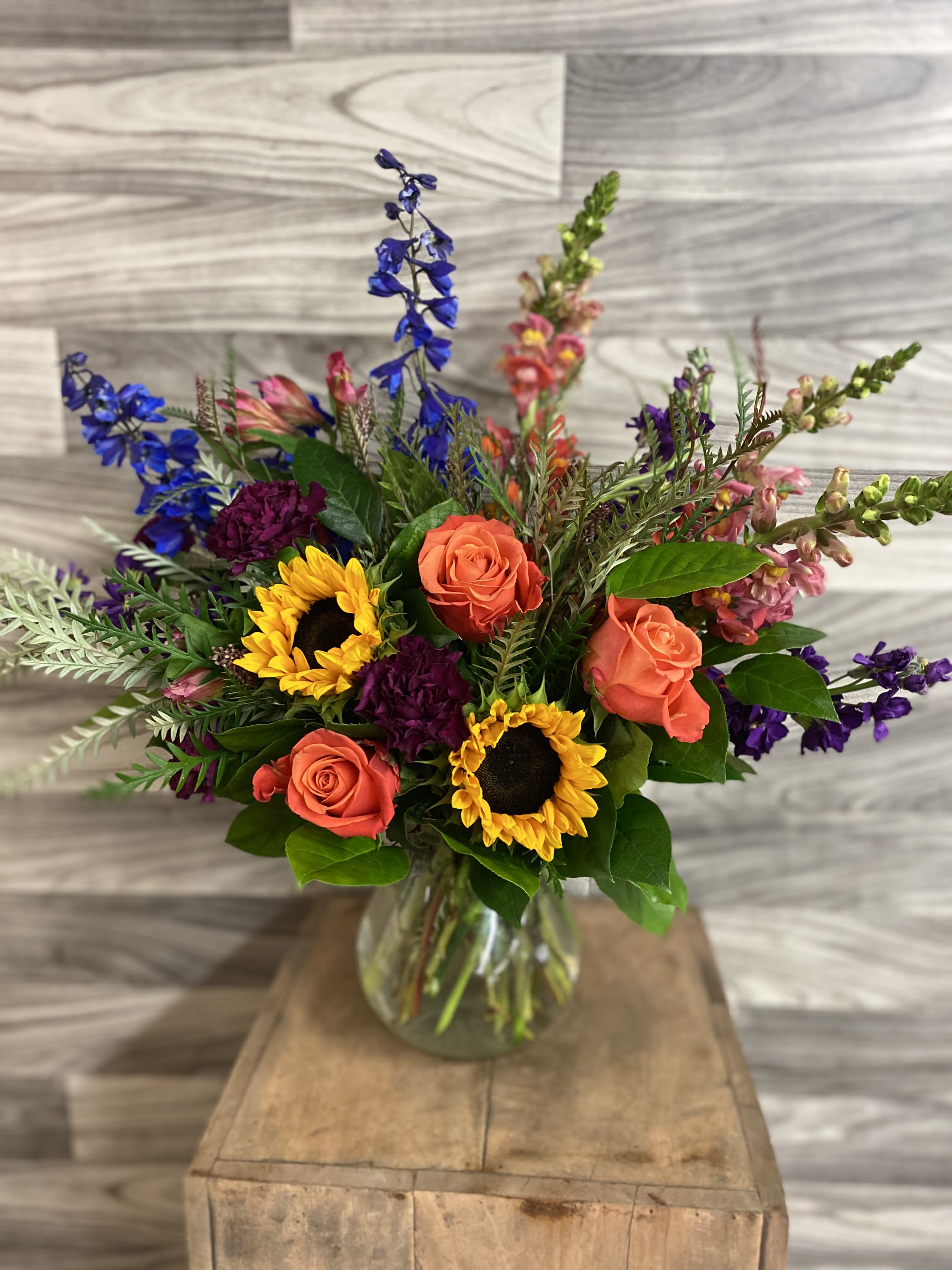 Ray of Sunshine Ray of Sunshine - A lush medium bouquet full of snapdragons, bella donna, stock, carnations, roses, and the show stopper sunflowers! It is an all around arrangement sure to brighten anyday.