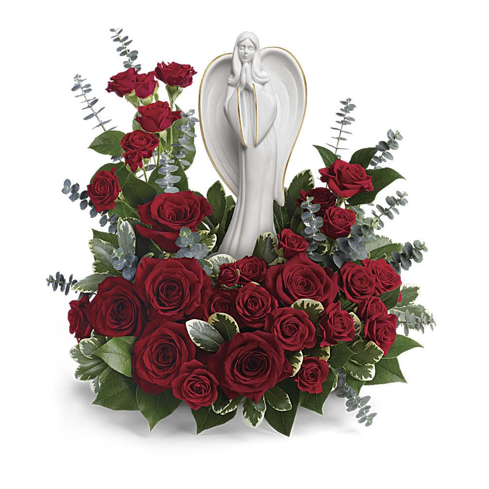Forever Our Angel Bouquet - Elegant and emotional, this touching arrangement of rich red roses with delicate greens surrounds a peaceful porcelain angel sculpture keepsake. This radiant bouquet includes red roses, red spray roses, spiral eucalyptus, variegated pittosporum, and lemon leaf. Delivered with The Angel of Grace Keepsake. Orientation: One-Sided